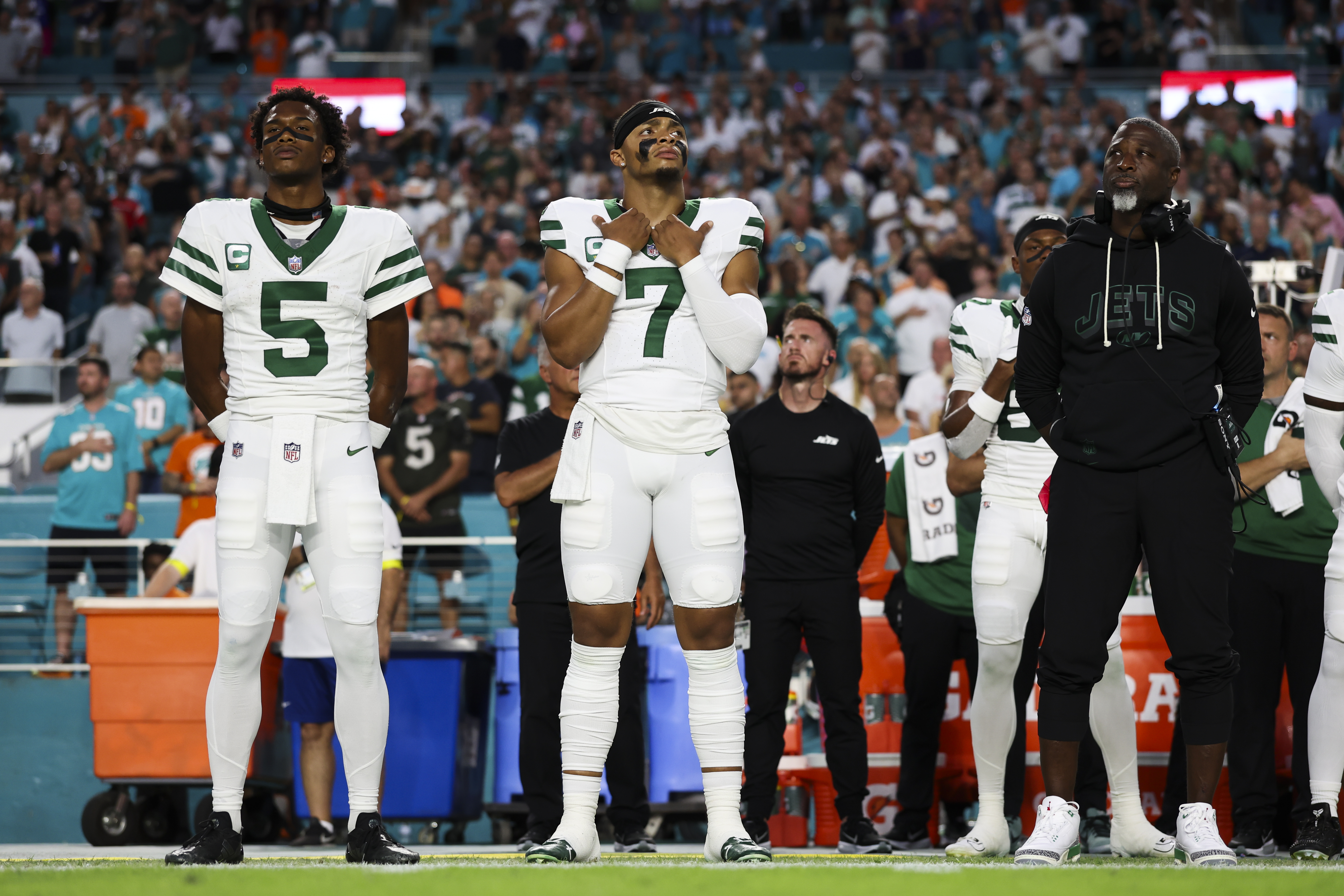 MIAMI GARDENS, FLORIDA - SEPTEMBER 29: Garrett Wilson #5, Justin Fields #7, and Head coach Aaron Glenn of the New York Jets stand on the sidelines during the national anthem prior to a NFL football game against the Miami Dolphins at Hard Rock Stadium on September 29, 2025 in Miami Gardens, Florida. (Photo by Logan Bowles/Getty Images)