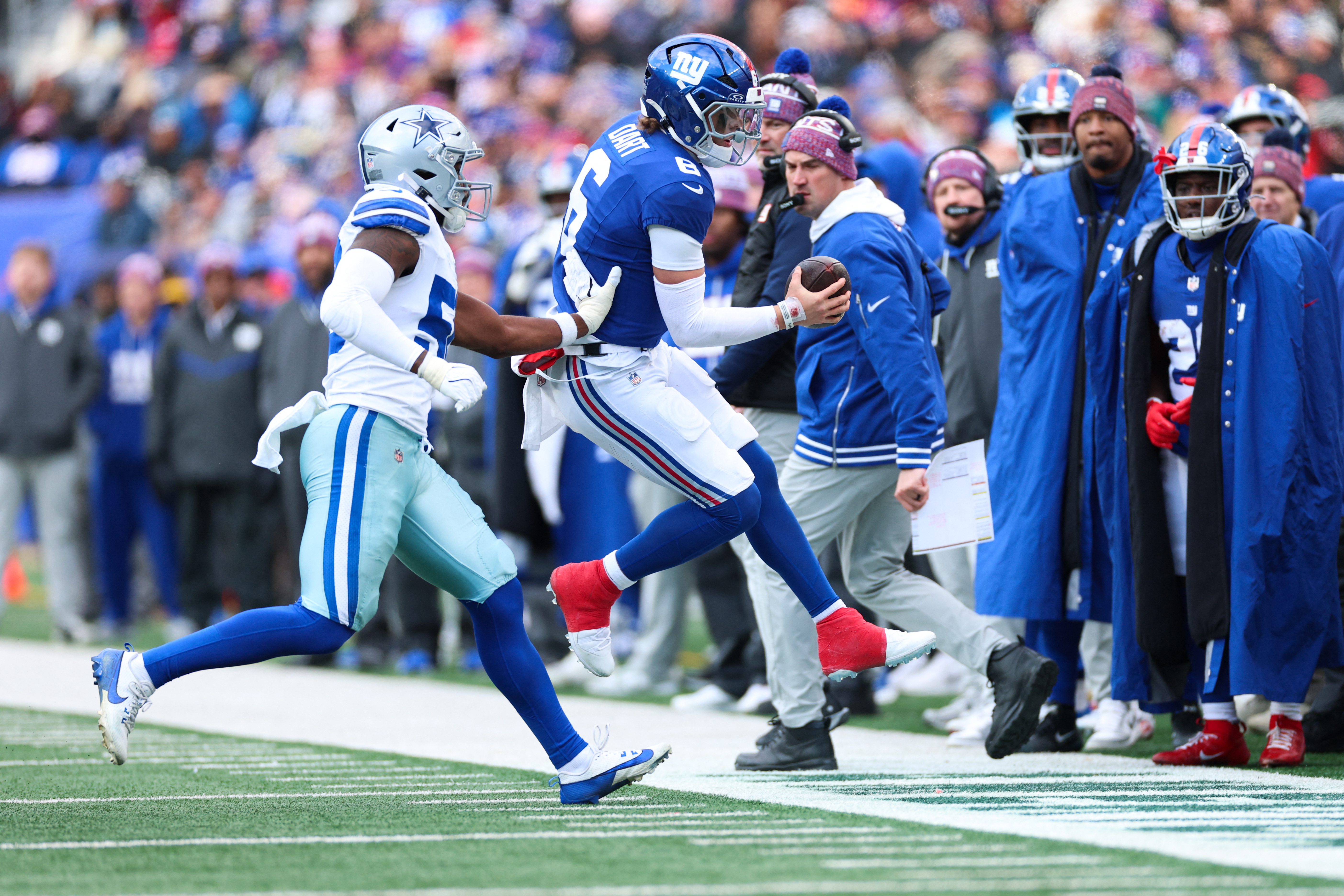Jan 4, 2026; East Rutherford, New Jersey, USA;  New York Giants quarterback Jaxson Dart (6) scrambles out of bounds as Dallas Cowboys linebacker Shemar James (50) defends during the second quarter at MetLife Stadium. Mandatory Credit: Vincent Carchietta-Imagn Images