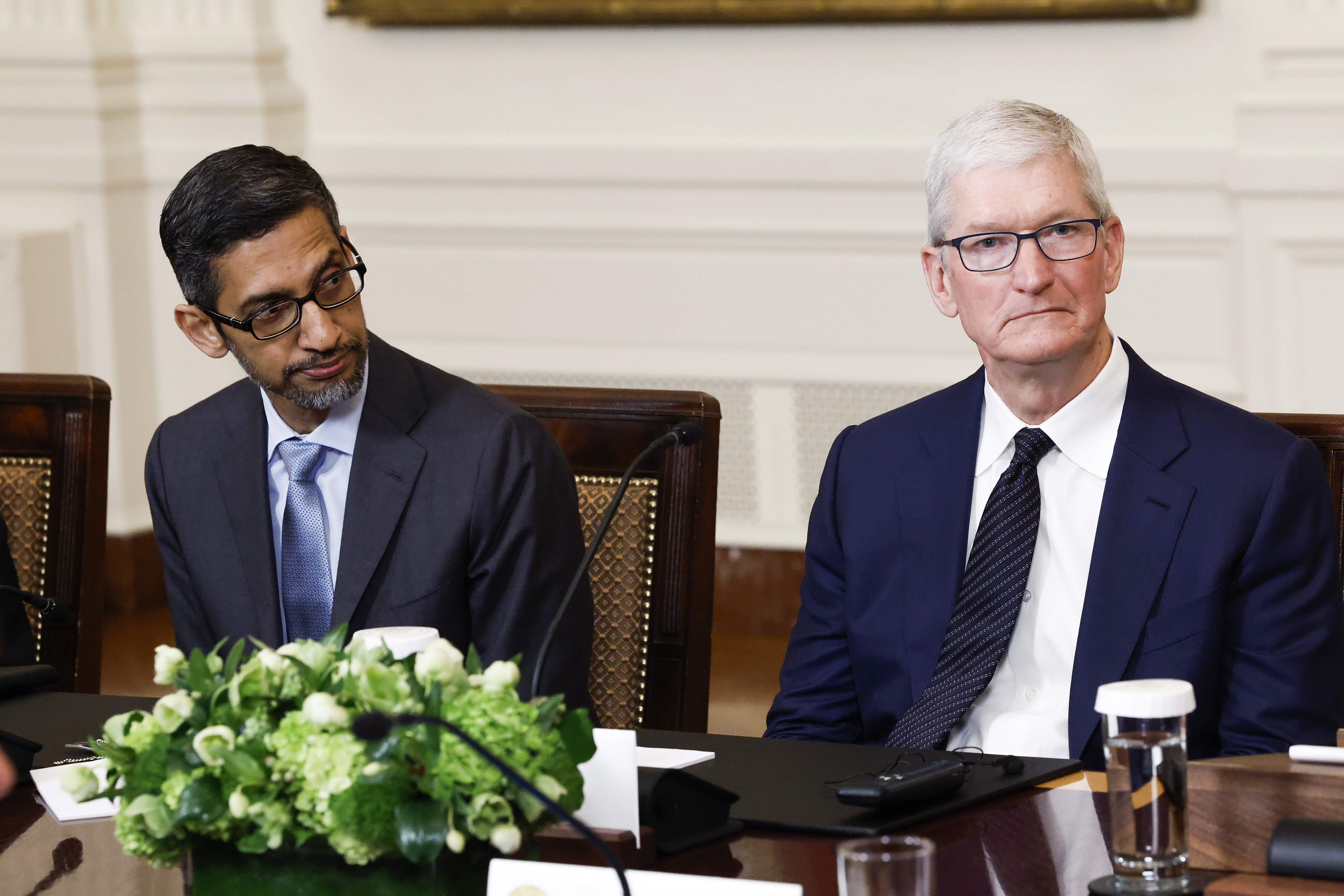 WASHINGTON, DC - JUNE 23: Google CEO Sundar Pichai (L) and Apple CEO Tim Cook (R) listen as U.S. President Joe Biden speaks during a roundtable with American and Indian business leaders in the East Room of the White House on June 23, 2023 in Washington, DC. Biden and Indian Prime Minister Narendra Modi held the meeting to meet with a range of leaders from the tech and business worlds and to discuss topics including innovation and AI. (Photo by Anna Moneymaker/Getty Images)