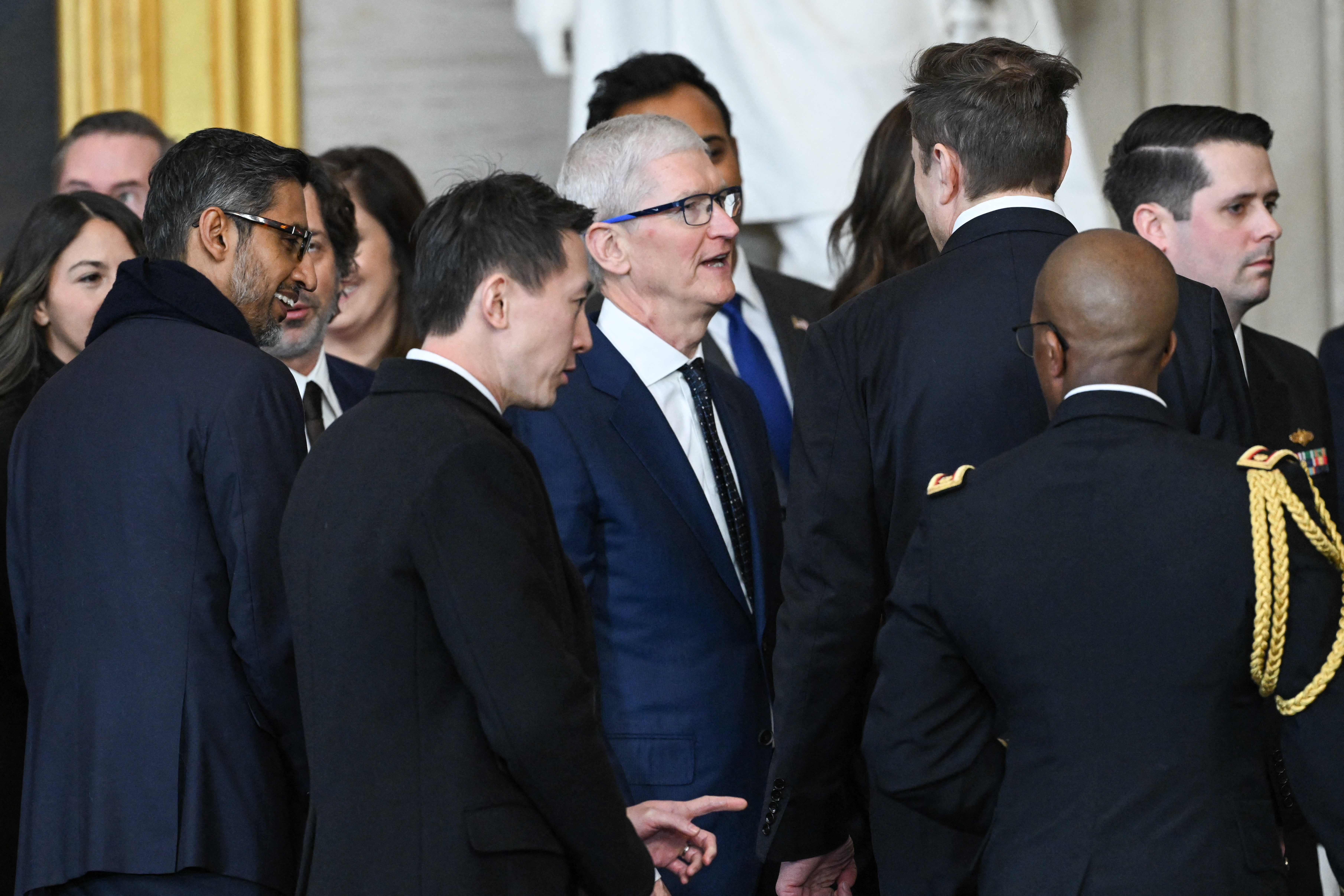 (L-R) Google CEO Sundar Pichai, TikTok CEO Shou Chew, Apple CEO Tim Cook and Tesla and SpaceX CEO Elon Musk speak with each other at the conclusion of the inauguration ceremony where President Donald Trump was sworn in as the 47th US President in the US Capitol Rotunda in Washington, DC, on January 20, 2025. (Photo by SAUL LOEB / POOL / AFP) (Photo by SAUL LOEB/POOL/AFP via Getty Images)