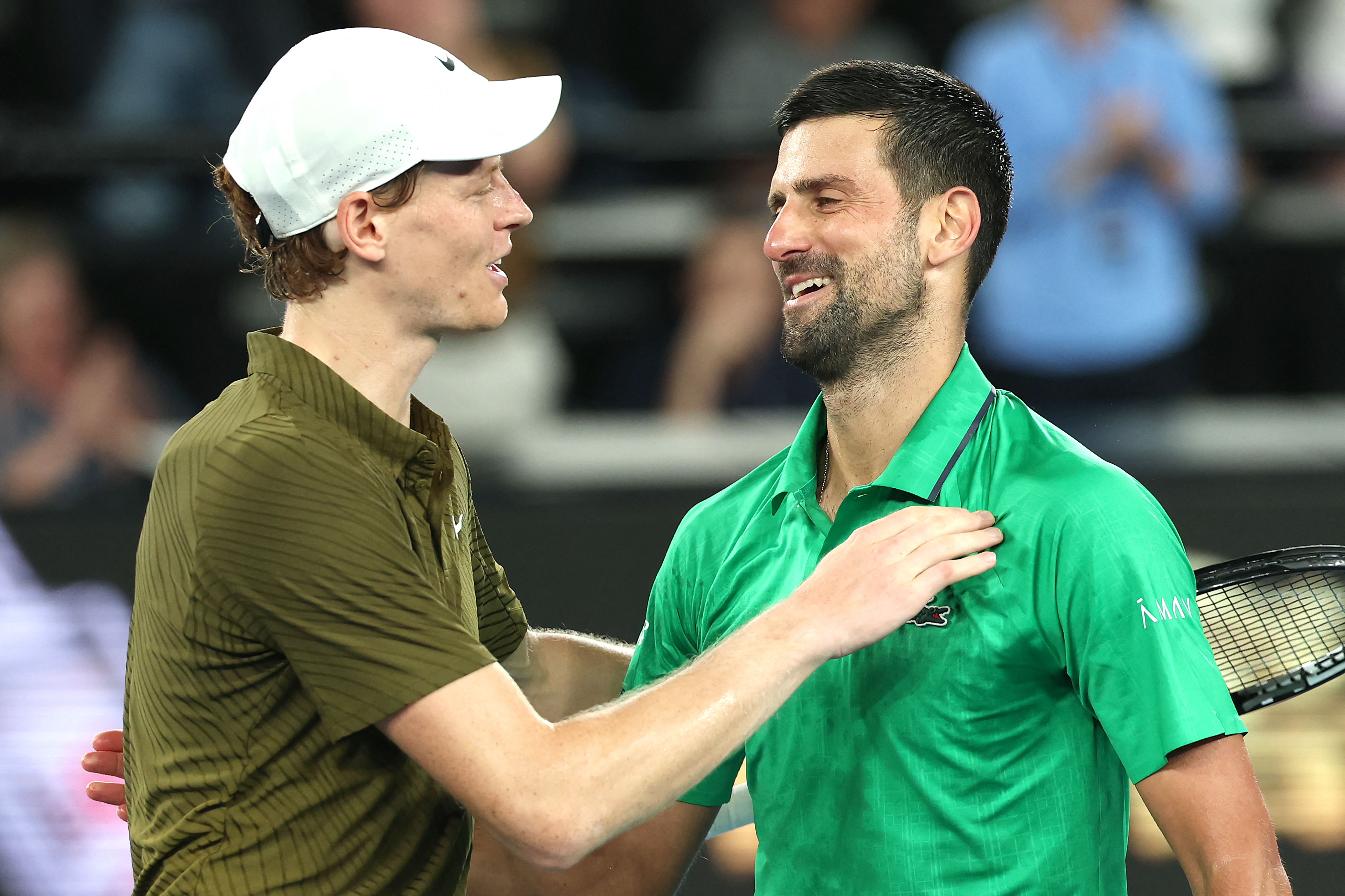 Serbia's Novak Djokovic (R) embraces Italy's Jannik Sinner after their men's singles semi-final match on day thirteen of the Australian Open tennis tournament in Melbourne on January 31, 2026. (Photo by Martin KEEP / AFP via Getty Images) / -- IMAGE RESTRICTED TO EDITORIAL USE - STRICTLY NO COMMERCIAL USE --
