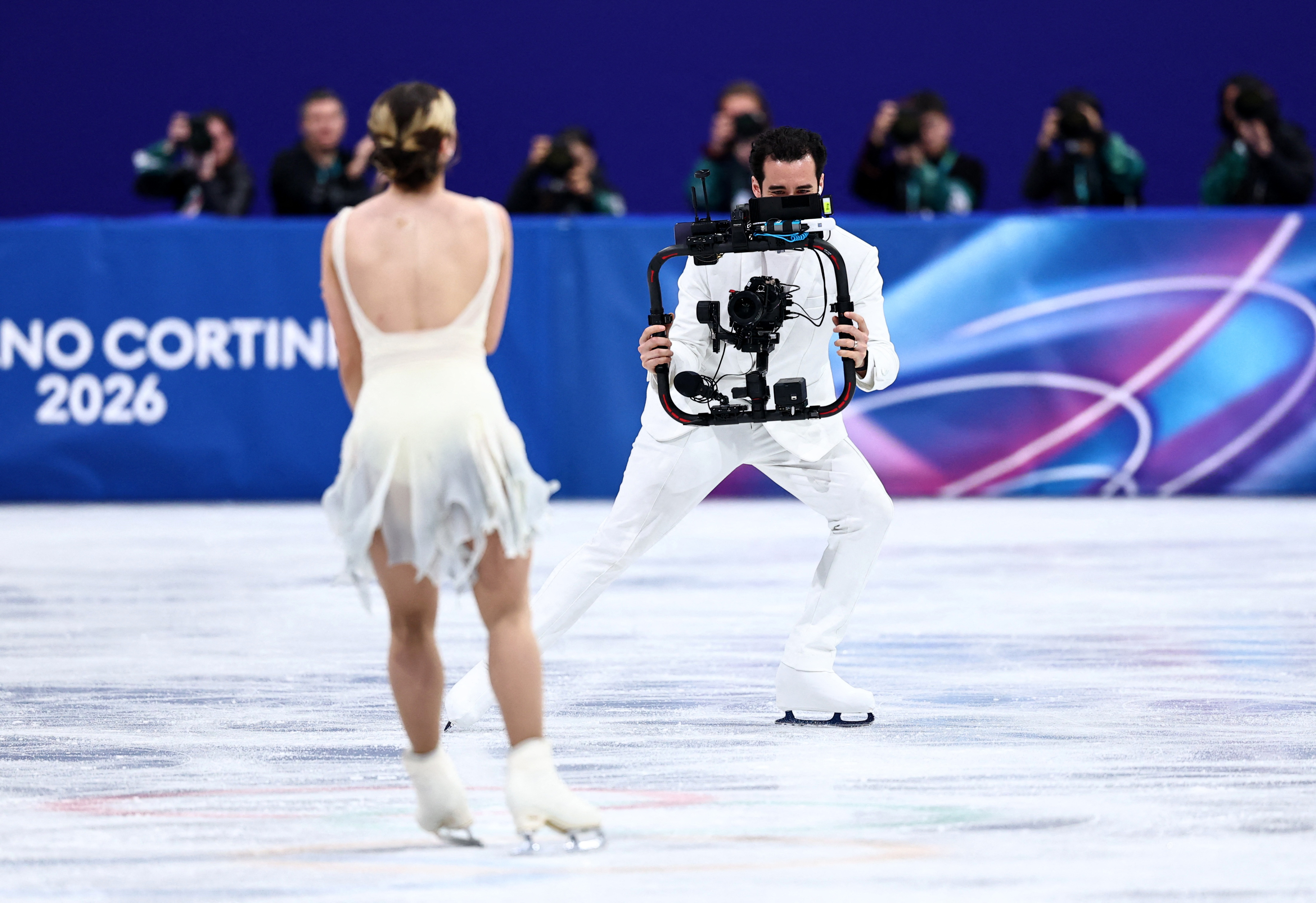 Milano Cortina 2026 Olympics - Figure Skating - Women Single Skating - Short Program - Milano Ice Skating Arena, Milan, Italy - February 17, 2026. Camera operator and former ice dancer Jordan Cowan on the ice after Alysa Liu of United States performs during the Short Program REUTERS/Amanda Perobelli