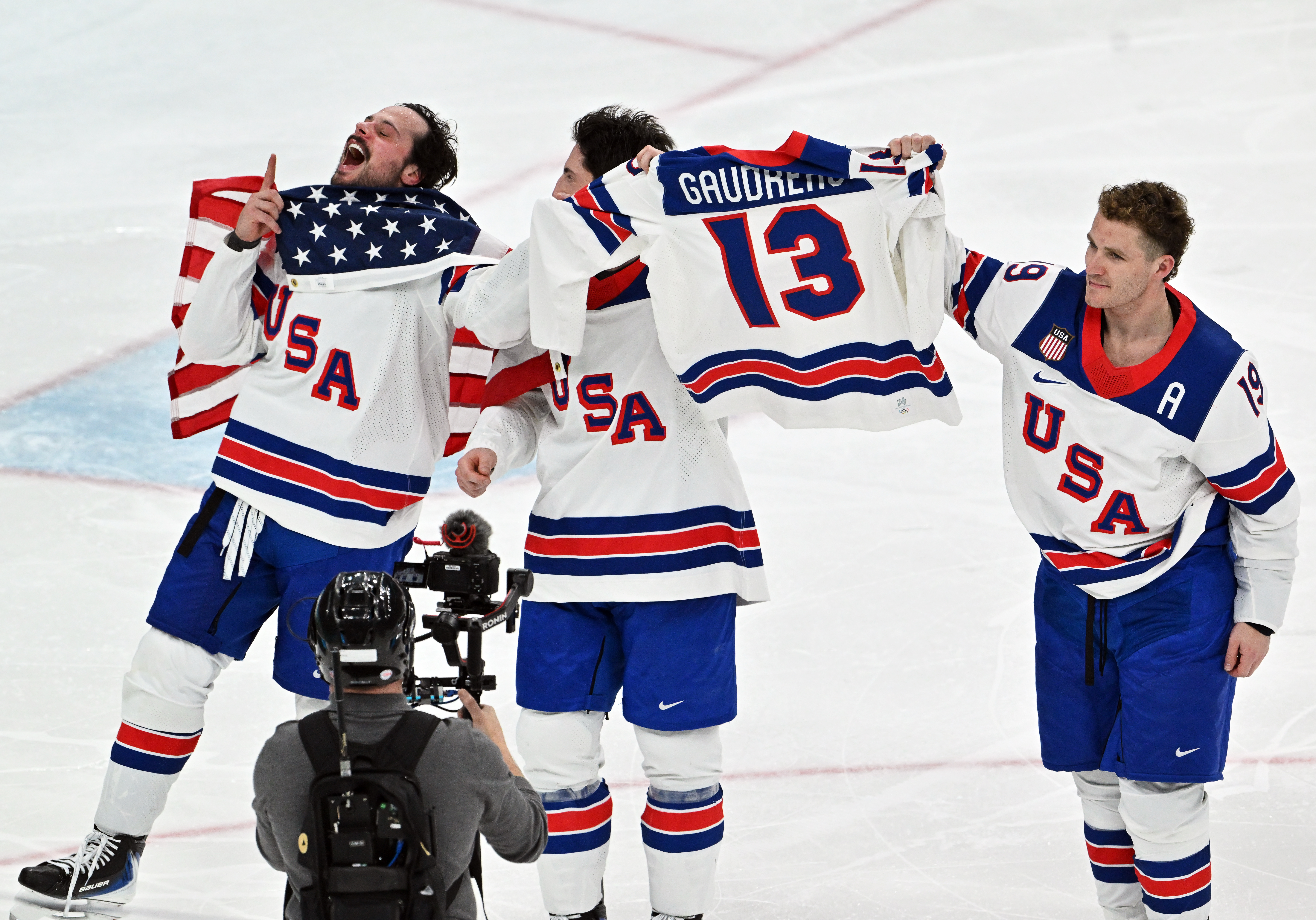 dpatop - 22 February 2026, Italy, Mailand: Olympia, Olympic Winter Games Milan Cortina 2026, ice hockey, men, Canada - USA, final round, final, USA players cheer for victory with a jersey of the late Johnny Gaudreau. Photo: Peter Kneffel/dpa (Photo by Peter Kneffel/picture alliance via Getty Images)