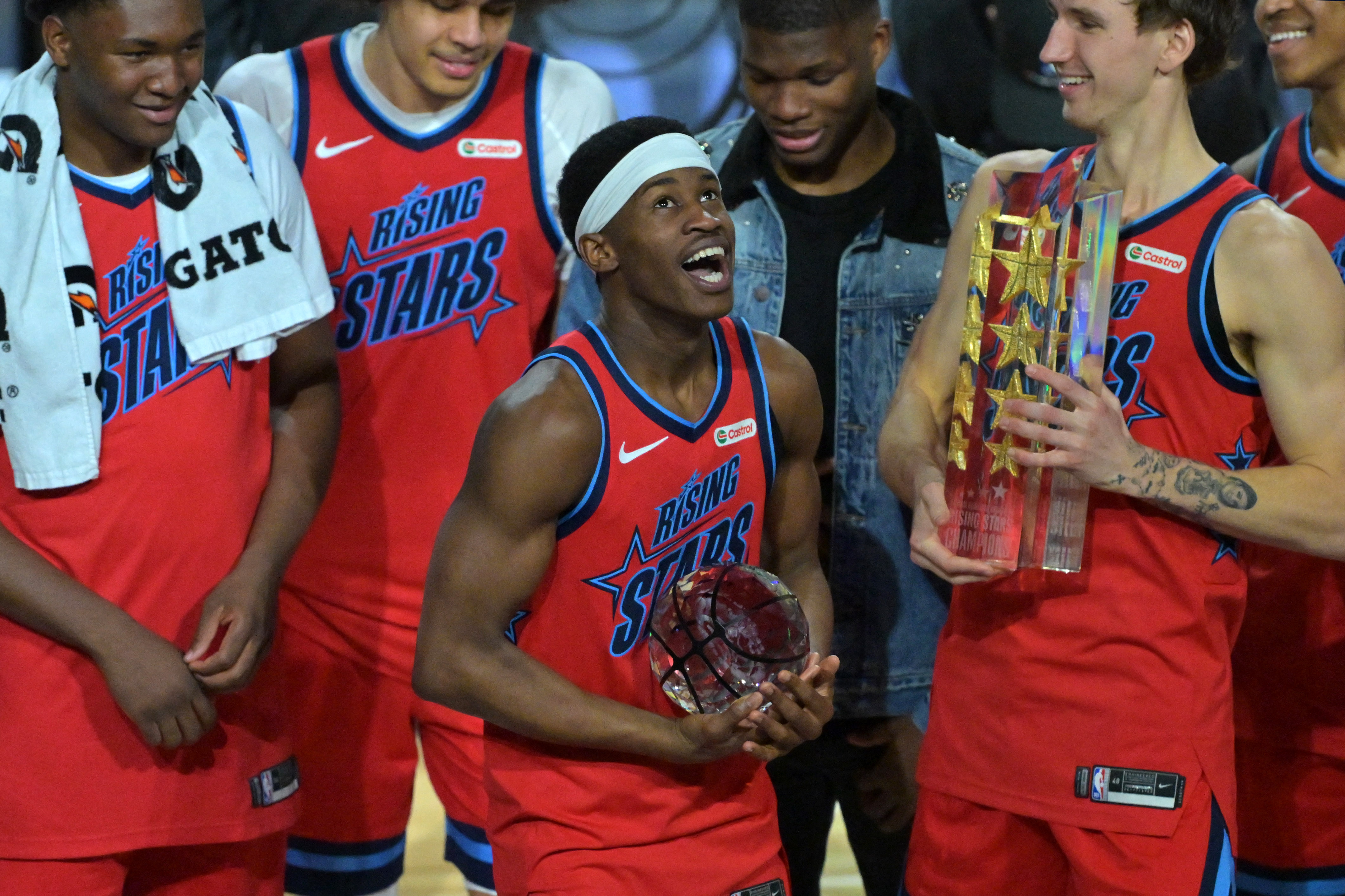 Feb 13, 2026; Inglewood, California, USA; Team Vince guard VJ Edgecombe (77) of the Philadelphia 76ers reacts with the MVP trophy after defeating Team Melo during an NBA All Star Rising Stars championship game at Intuit Dome. Mandatory Credit: Jayne Kamin-Oncea-Imagn Images