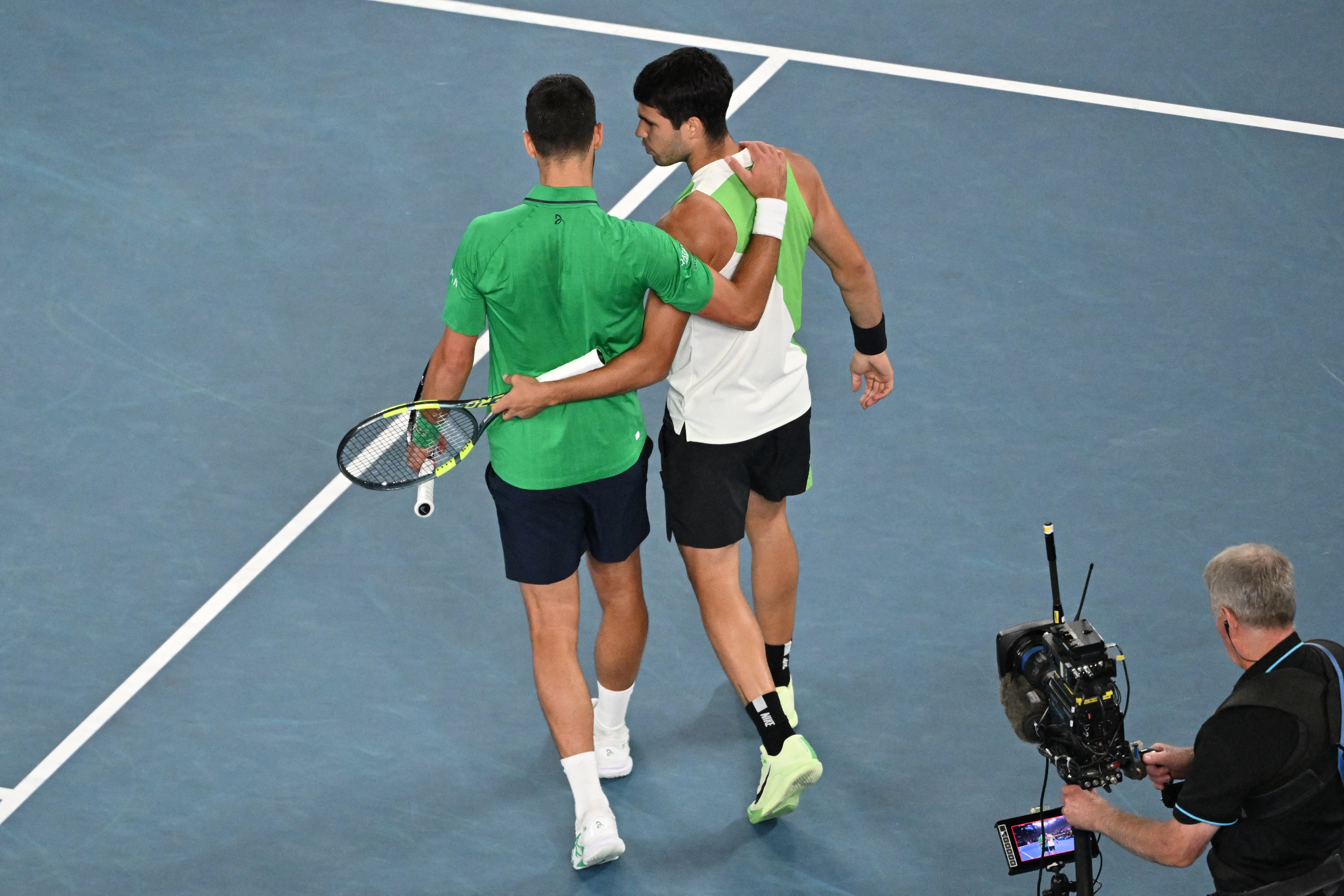 Spain's Carlos Alcaraz (R) speaks with Serbia's Novak Djokovic after victory during their men's singles final match on day fifteen of the Australian Open tennis tournament in Melbourne on February 1, 2026. (Photo by Paul Crock / AFP via Getty Images) / -- IMAGE RESTRICTED TO EDITORIAL USE - STRICTLY NO COMMERCIAL USE --