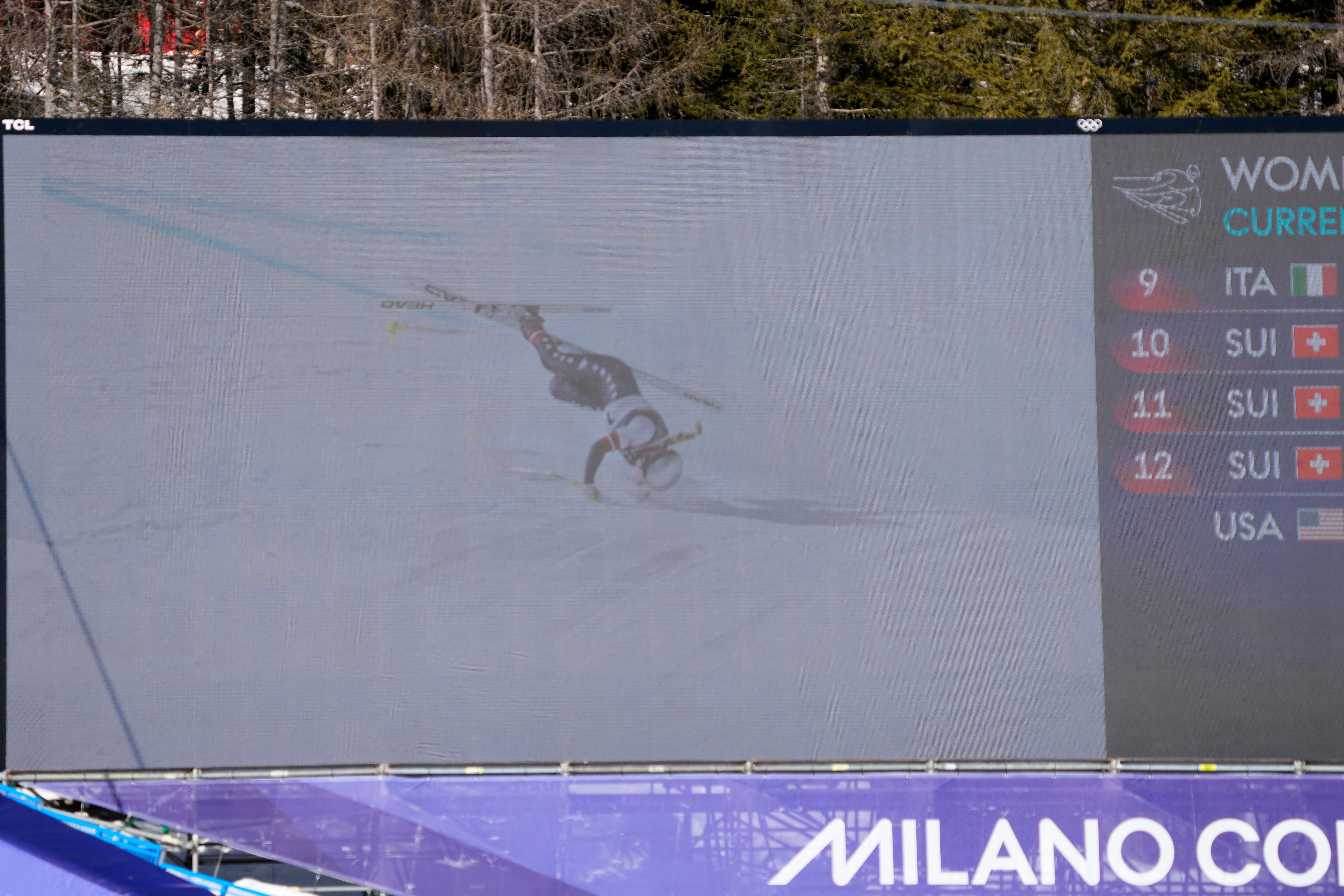 United States' Lindsey Vonn's crash is seen on a giant screen at the finish area of an alpine ski women's downhill race, at the 2026 Winter Olympics, in Cortina d'Ampezzo, Italy, Sunday, Feb. 8, 2026. (AP Photo/Andy Wong)