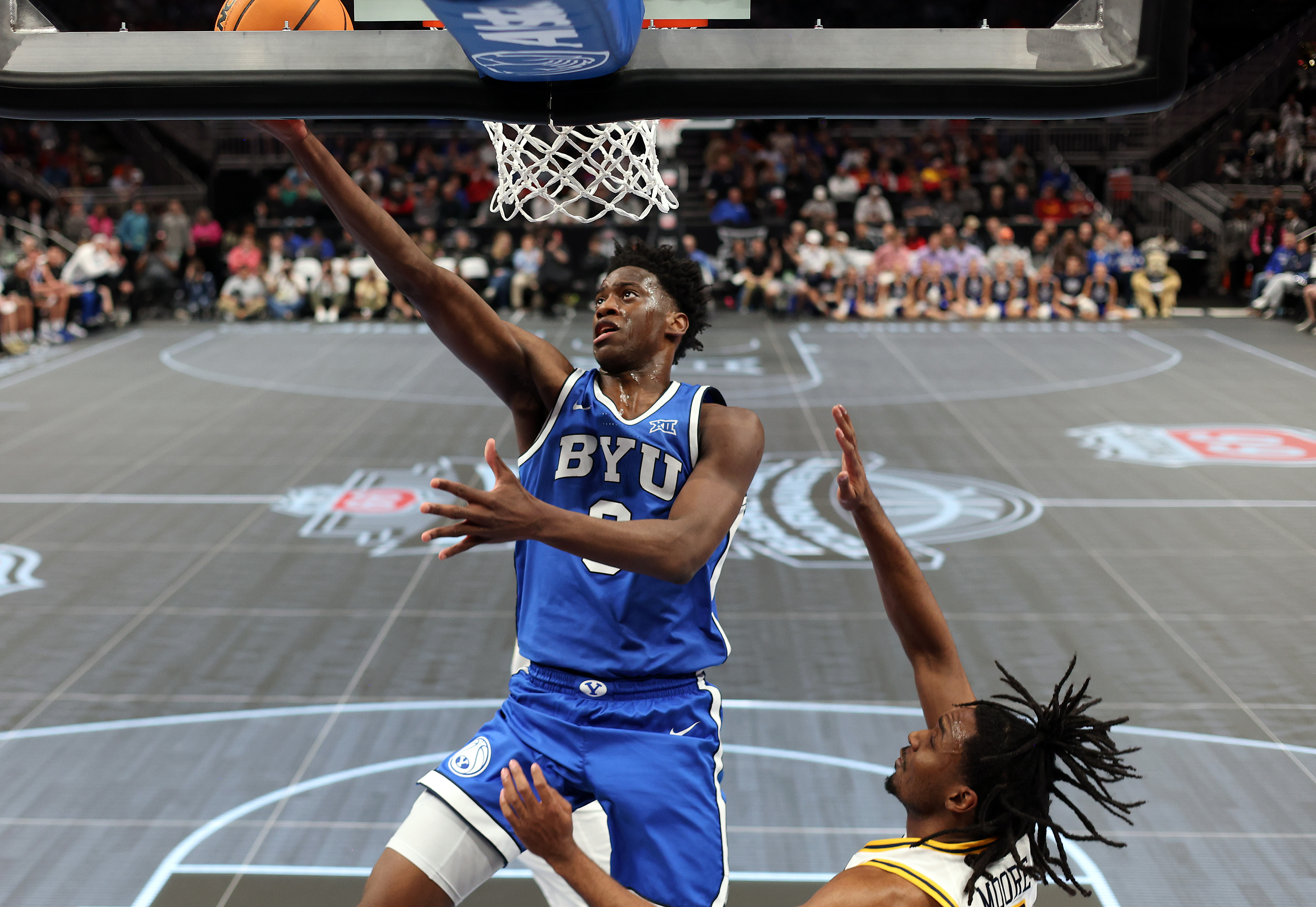 KANSAS CITY, MISSOURI - MARCH 11: AJ Dybantsa #3 of the BYU Cougars drives to the basket as Chance Moore #13 of the West Virginia Mountaineers defends during the second round game of the Men's 2026 Big 12 Tournament at T-Mobile Center on March 11, 2026 in Kansas City, Missouri. (Photo by Jamie Squire/Getty Images)
