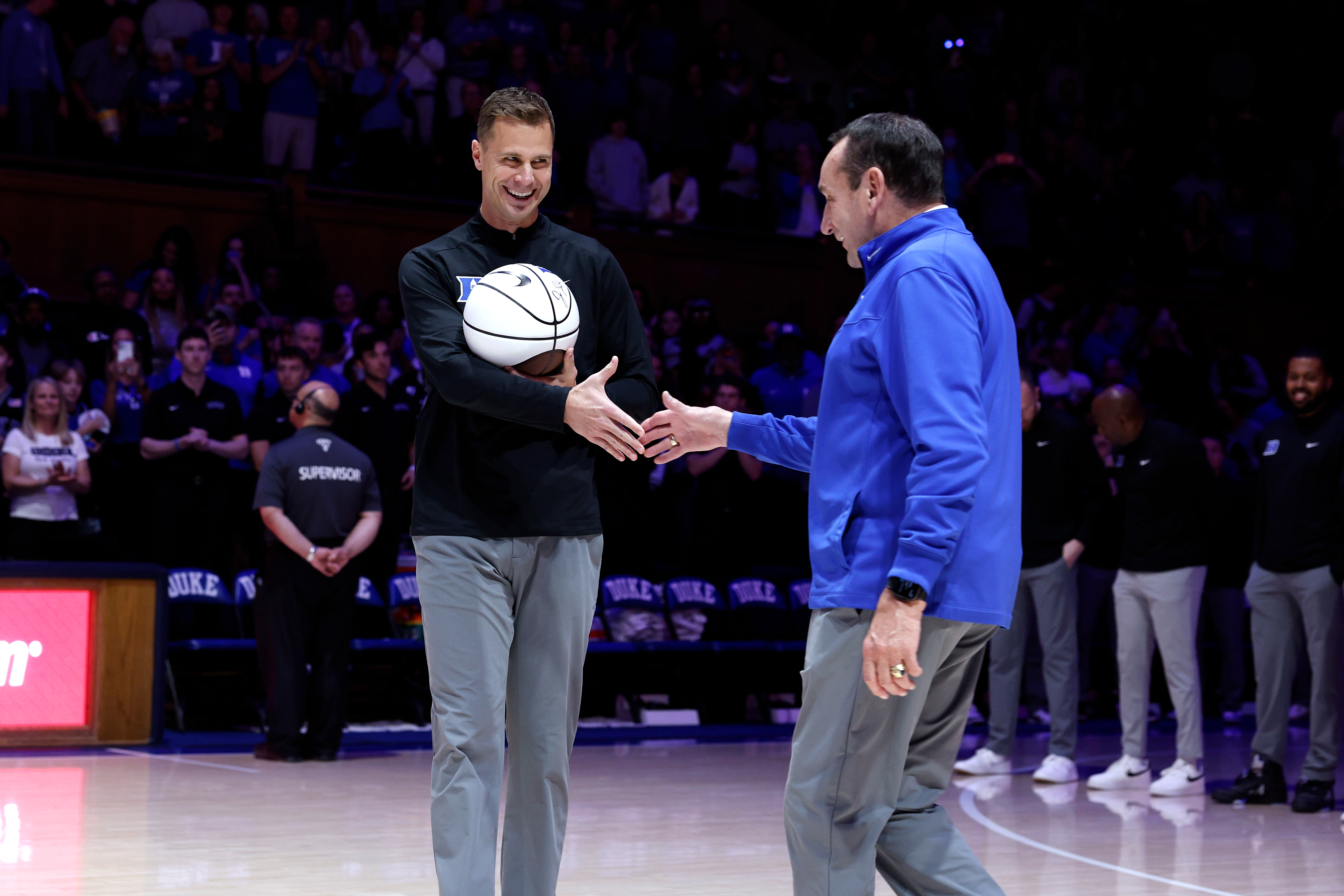 DURHAM, NORTH CAROLINA - NOVEMBER 23: Head coach Jon Scheyer (L) of the Duke Blue Devils shakes hands with Duke University ambassador Mike Krzyzewski prior to the game against the Howard Bison at Cameron Indoor Stadium on November 23, 2025 in Durham, North Carolina. (Photo by Lance King/Getty Images)