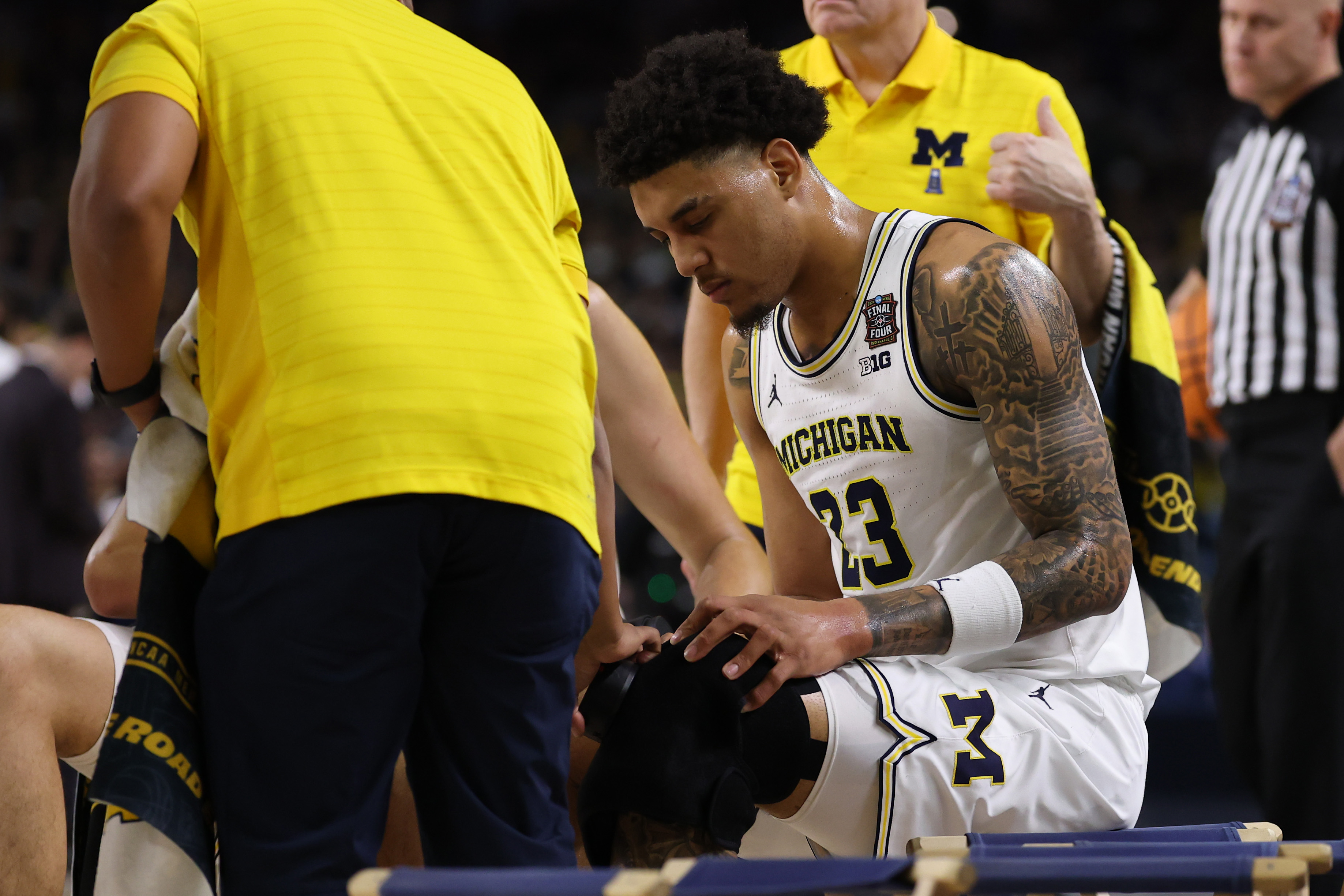 INDIANAPOLIS, INDIANA - APRIL 06: Yaxel Lendeborg #23 of the Michigan Wolverines is attended to by training staff during the first half of a game against the UConn Huskies in the National Championship of the 2026 NCAA Men's Basketball Tournament at Lucas Oil Stadium on April 06, 2026 in Indianapolis, Indiana. (Photo by Patrick Smith/Getty Images)