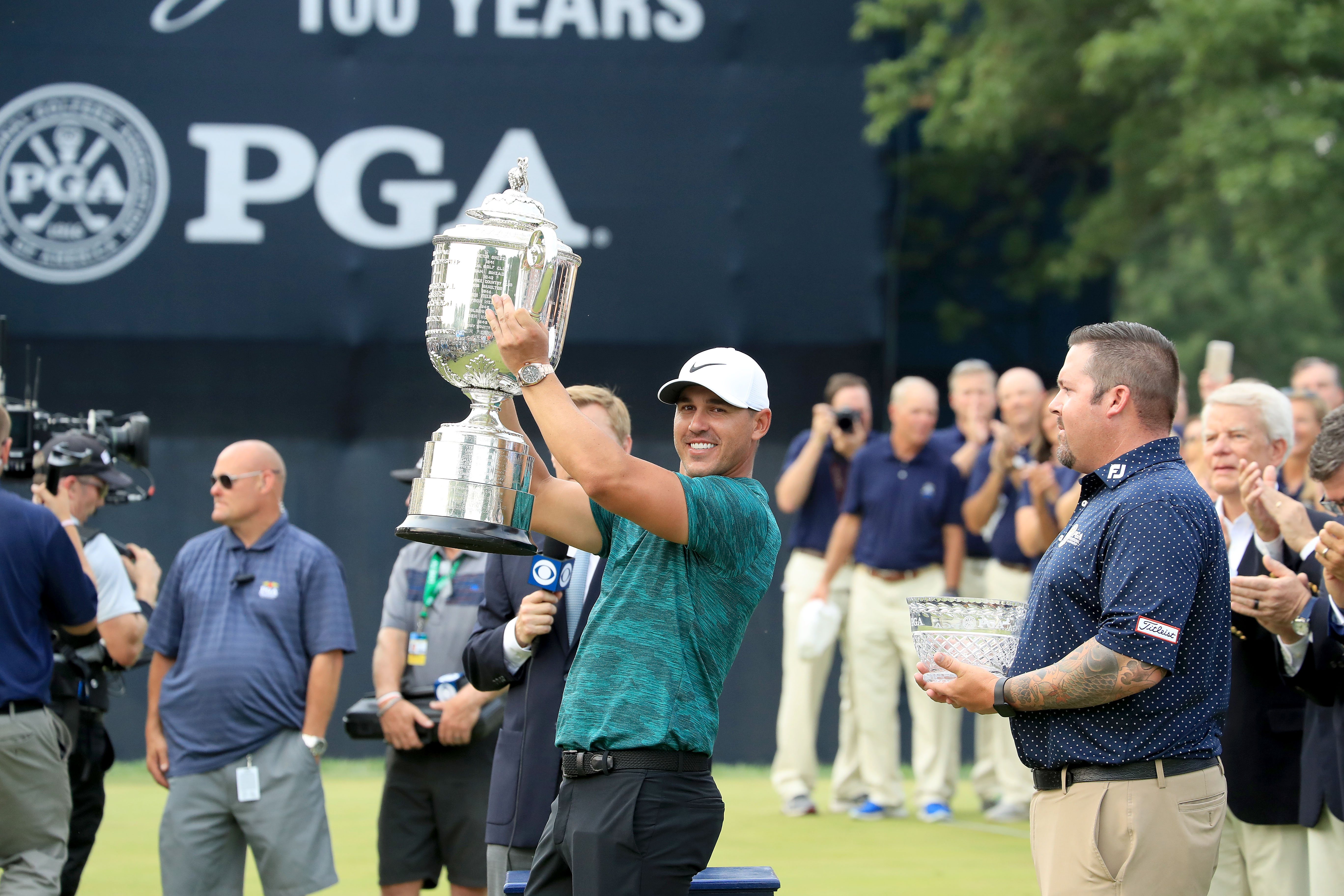 ST LOUIS, MO - AUGUST 12:  Brooks Koepka of the United States raises the Wannamaker Trophy watched by the leading club professional Ben Kern of the United States after his two stroke victory the final round of the 100th PGA Championship at the Bellerive Country Club on August 12, 2018 in St Louis, Missouri.  (Photo by David Cannon/Getty Images)