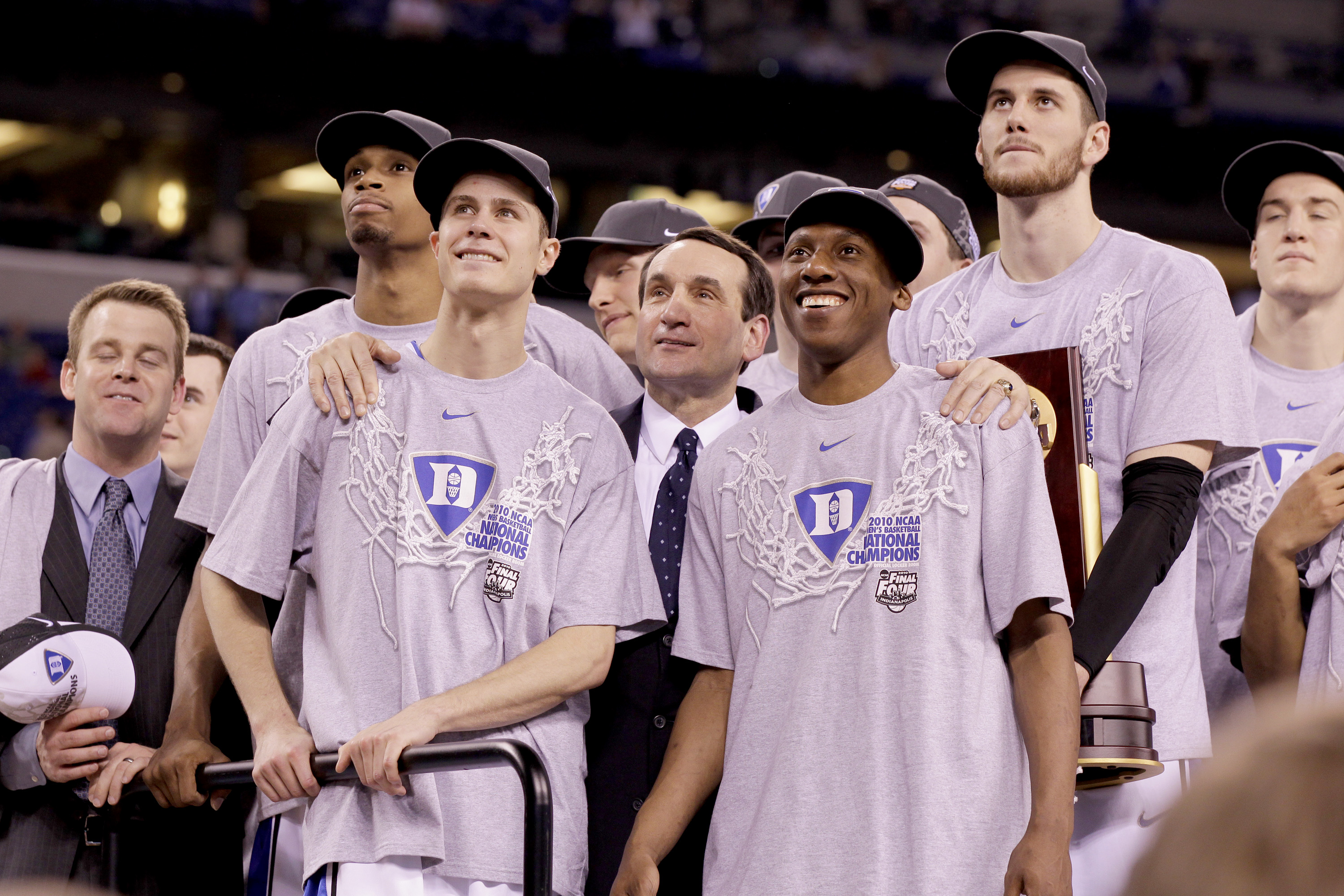 Duke head coach Mike Krzyzewski with arms on the shoulders of Jon Scheyer of Duke (30), left, and Nolan Smith of Duke (2) as they watch "One Shining Moment" during post-game ceremony after defeating Butler, 61-59, in the NCAA Final Four championship game at Lucas Oil Stadiuim in Indianapolis, Indiana, Monday, April 5, 2010.  (Photo by Mark Cornelison/Getty Images)