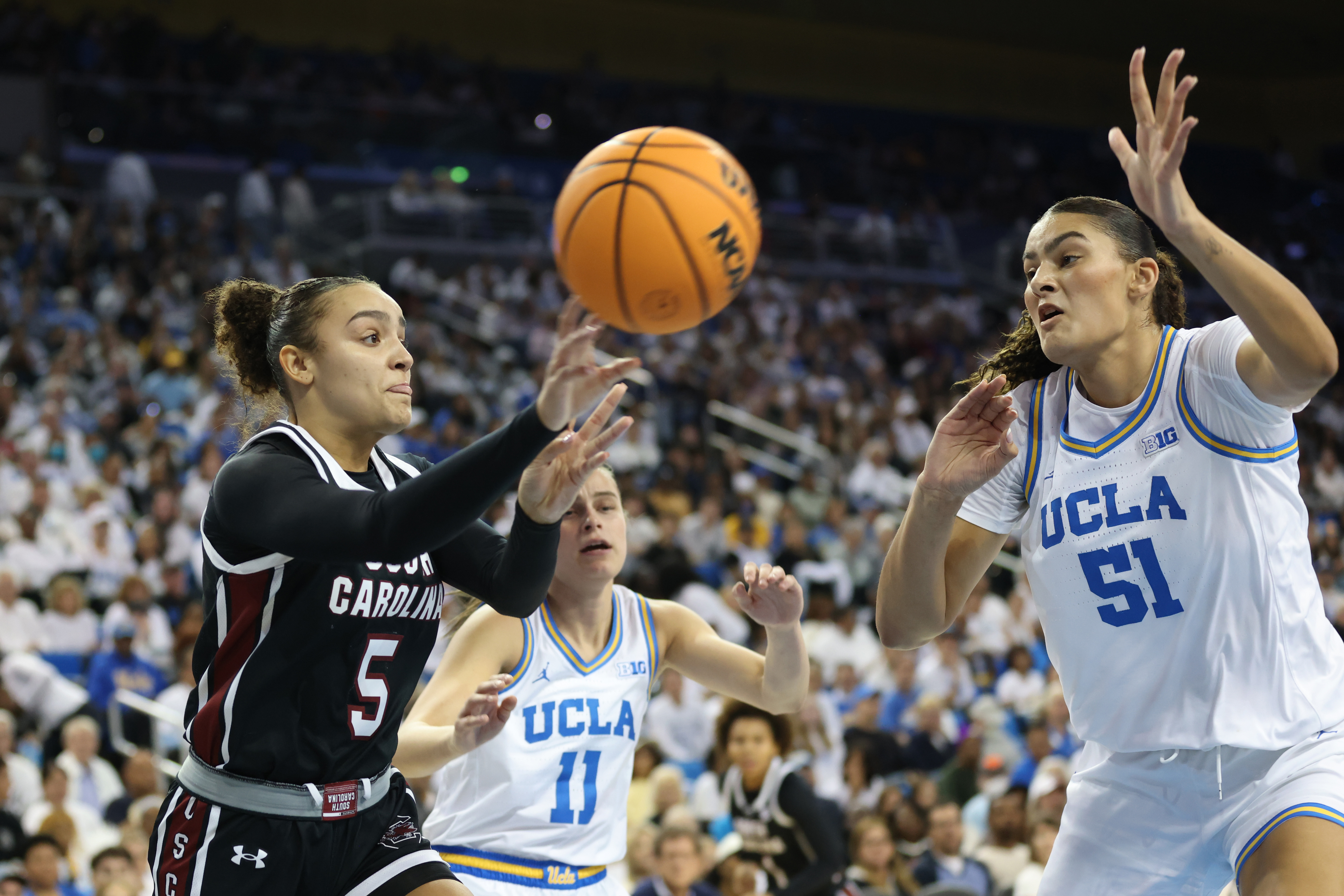 LOS ANGELES, CALIFORNIA - NOVEMBER 24: Tessa Johnson #5 of the South Carolina Gamecocks passes the ball past Lauren Betts #51 of the UCLA Bruins in the first quarter at UCLA Pauley Pavilion on November 24, 2024 in Los Angeles, California. (Photo by Joe Scarnici/Getty Images)