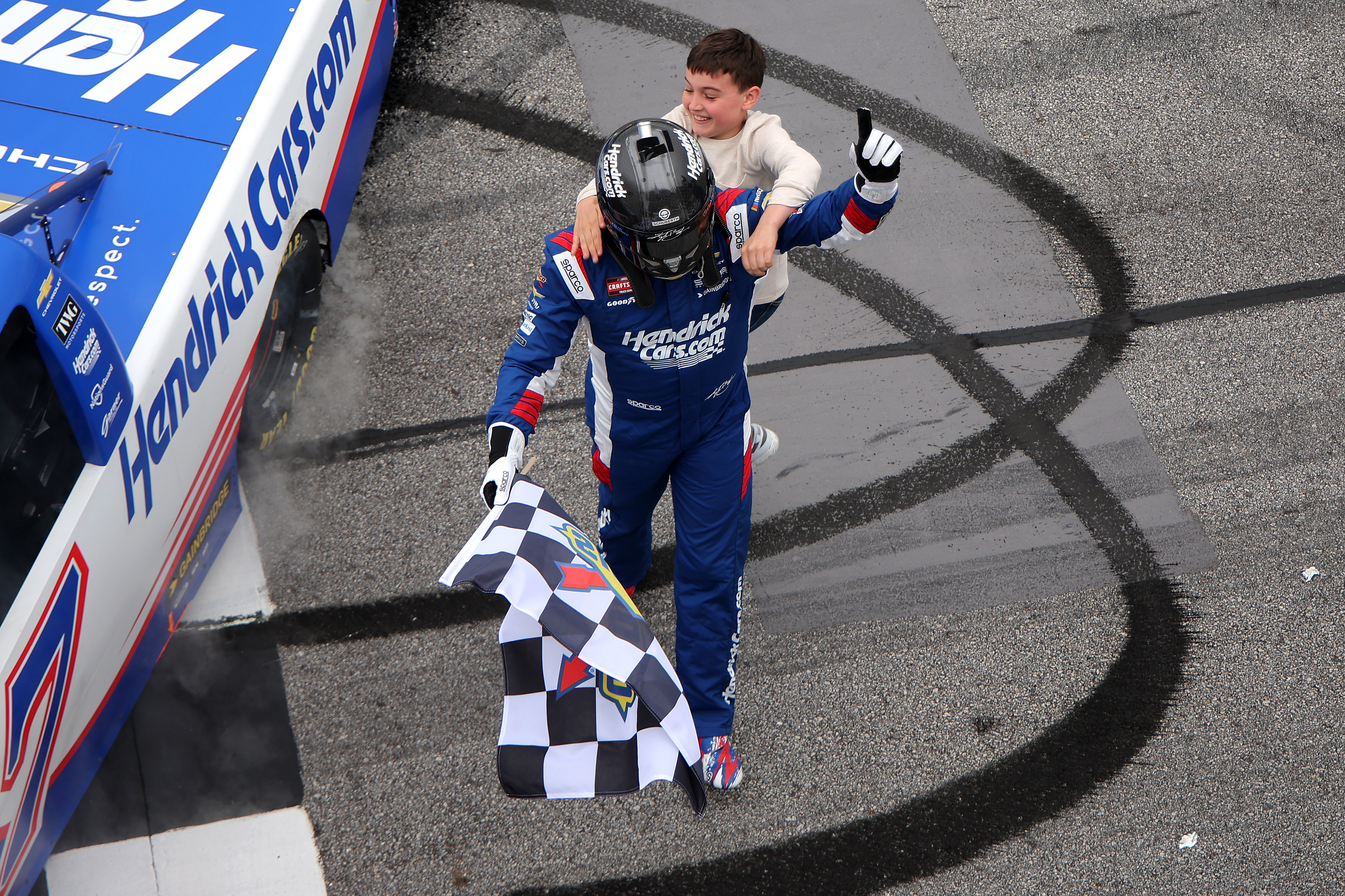 HAMPTON, GEORGIA - FEBRUARY 21: Kyle Busch, driver of the #7 HendrickCars.com Chevrolet, is congratulated by his son, Brexton Busch after winning the NASCAR Craftsman Truck Series Fr8 Racing 208 at Echo Park Speedway on February 21, 2026 in Hampton, Georgia. (Photo by Jonathan Bachman/Getty Images)