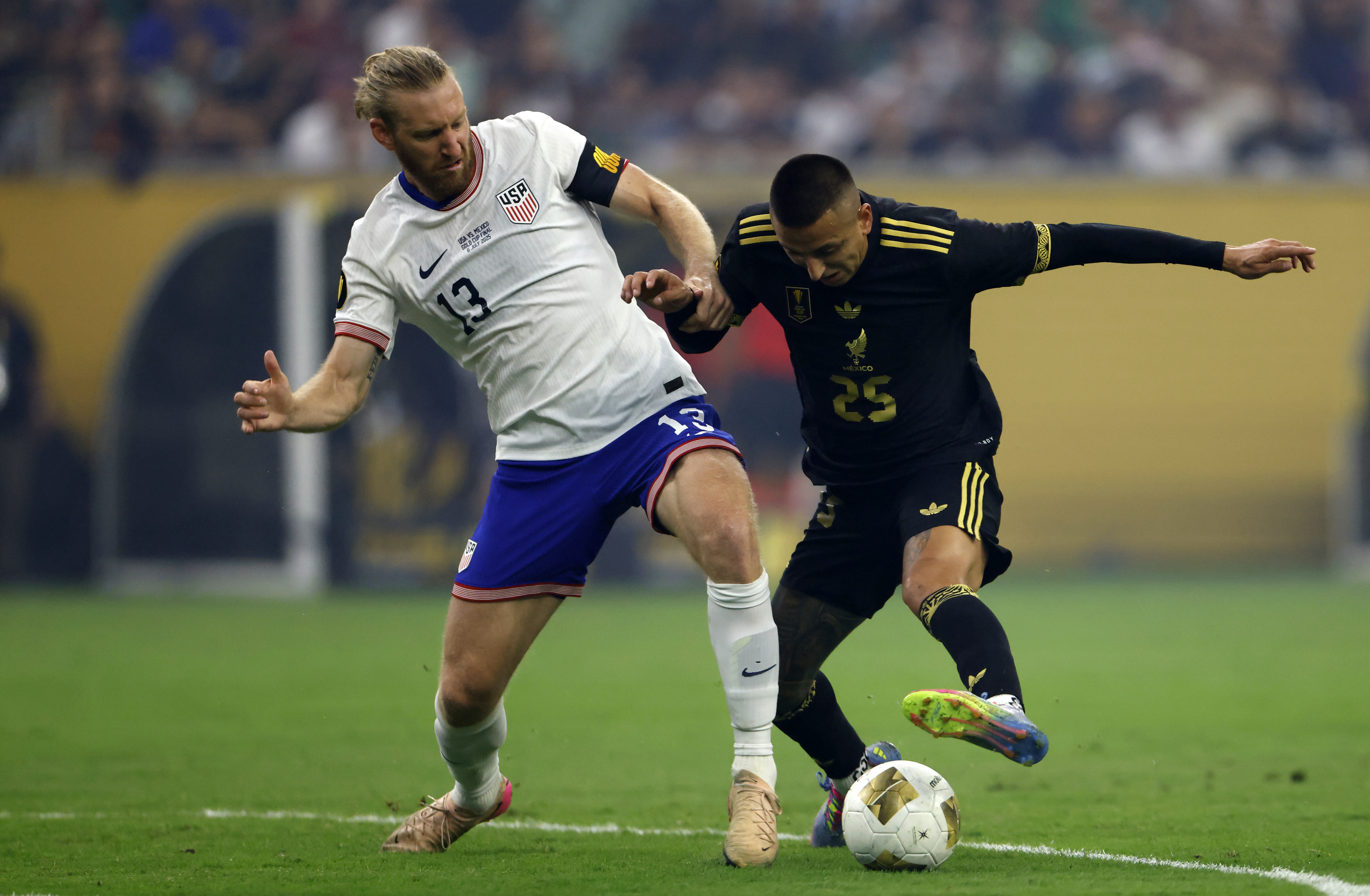 HOUSTON, TEXAS - JULY 06: Tim Ream #13 of the United States battles for the ball with Roberto Alvarado #25 of Mexico during the second half of the finals of the CONCACAF Gold Cup 2025 at NRG Stadium on July 06, 2025 in Houston, Texas. (Photo by Ron Jenkins/USSF/Getty Images)