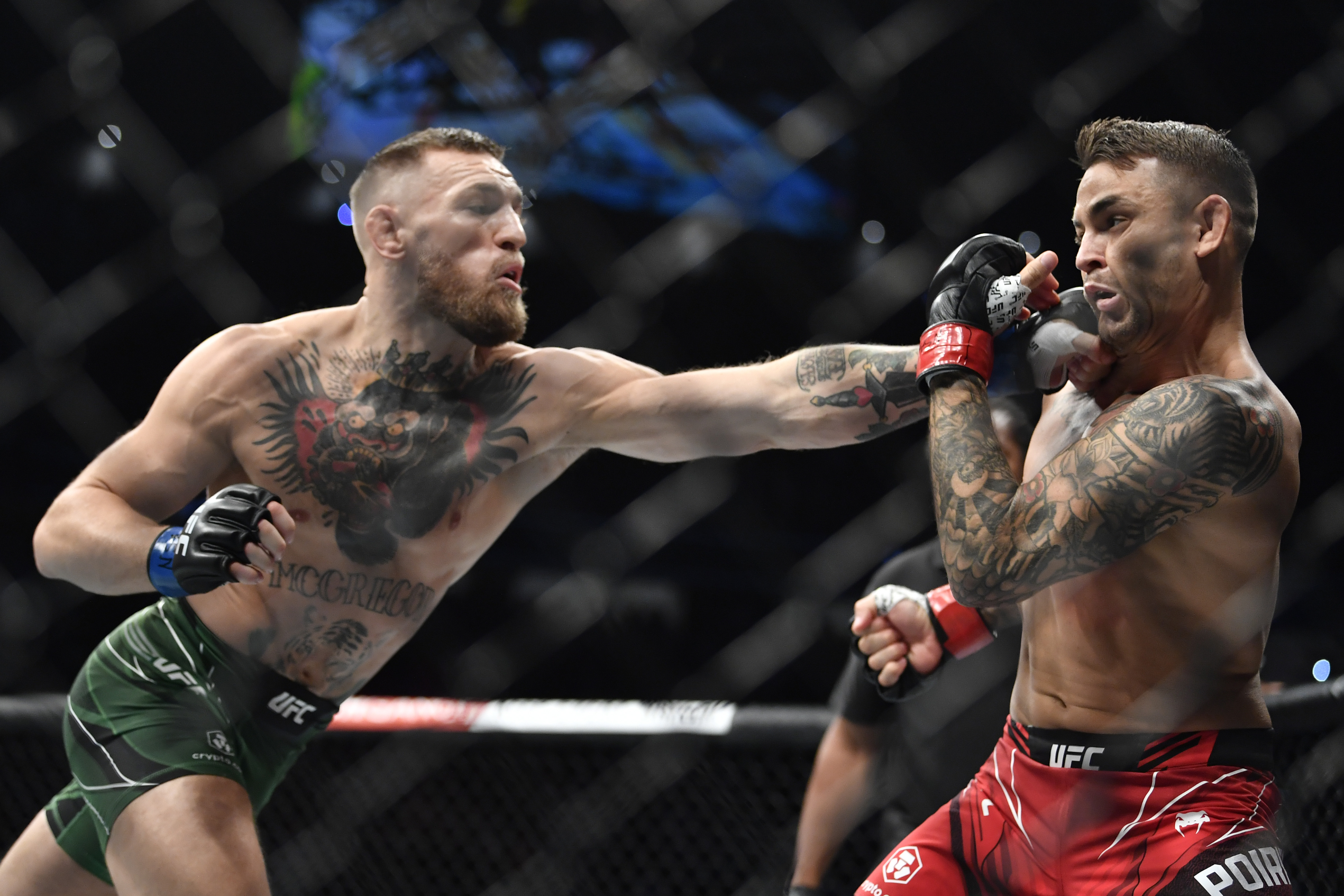 LAS VEGAS, NEVADA - JULY 10:  (L-R) Conor McGregor of Ireland punches Dustin Poirier during the UFC 264 event at T-Mobile Arena on July 10, 2021 in Las Vegas, Nevada. (Photo by Chris Unger/Zuffa LLC)