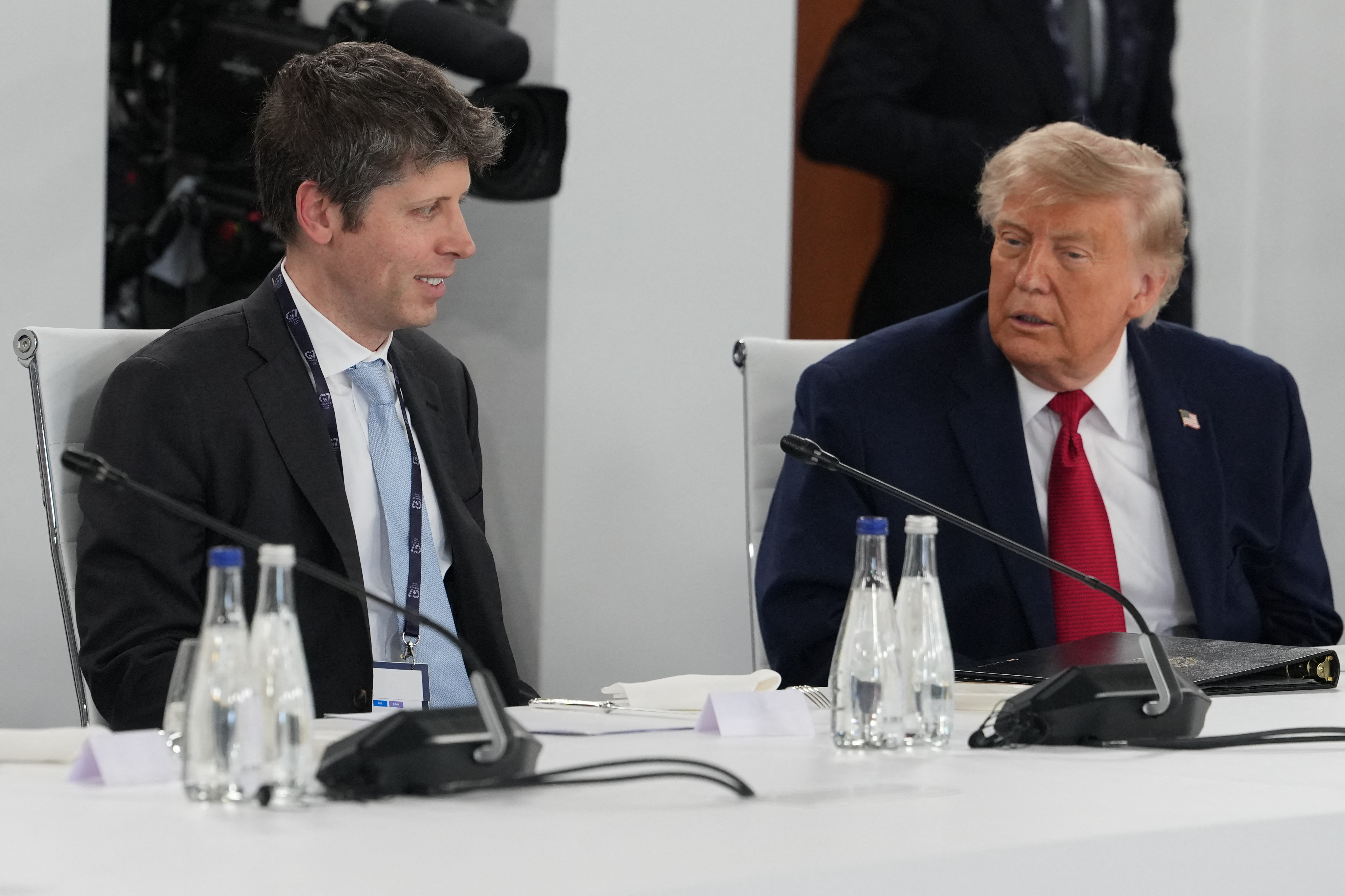 US President Donald Trump (R) and Open AI CEO Sam Altman (L) react during a working lunch meeting of G7 members, partner countries, and artificial intelligence business leaders as part of the G7 summit, in Evian, eastern France, on June 17, 2026. A G7 summit is set to take place June 15 to 17 in the French town of Evian-les-Bains near Switzerland and it will be attended by country leaders as well as the EU's foreign policy chief and ministers from Brazil, Canada, the United Arab Emirates and Turkey. (Photo by Julia Demaree Nikhinson / POOL / AFP via Getty Images)