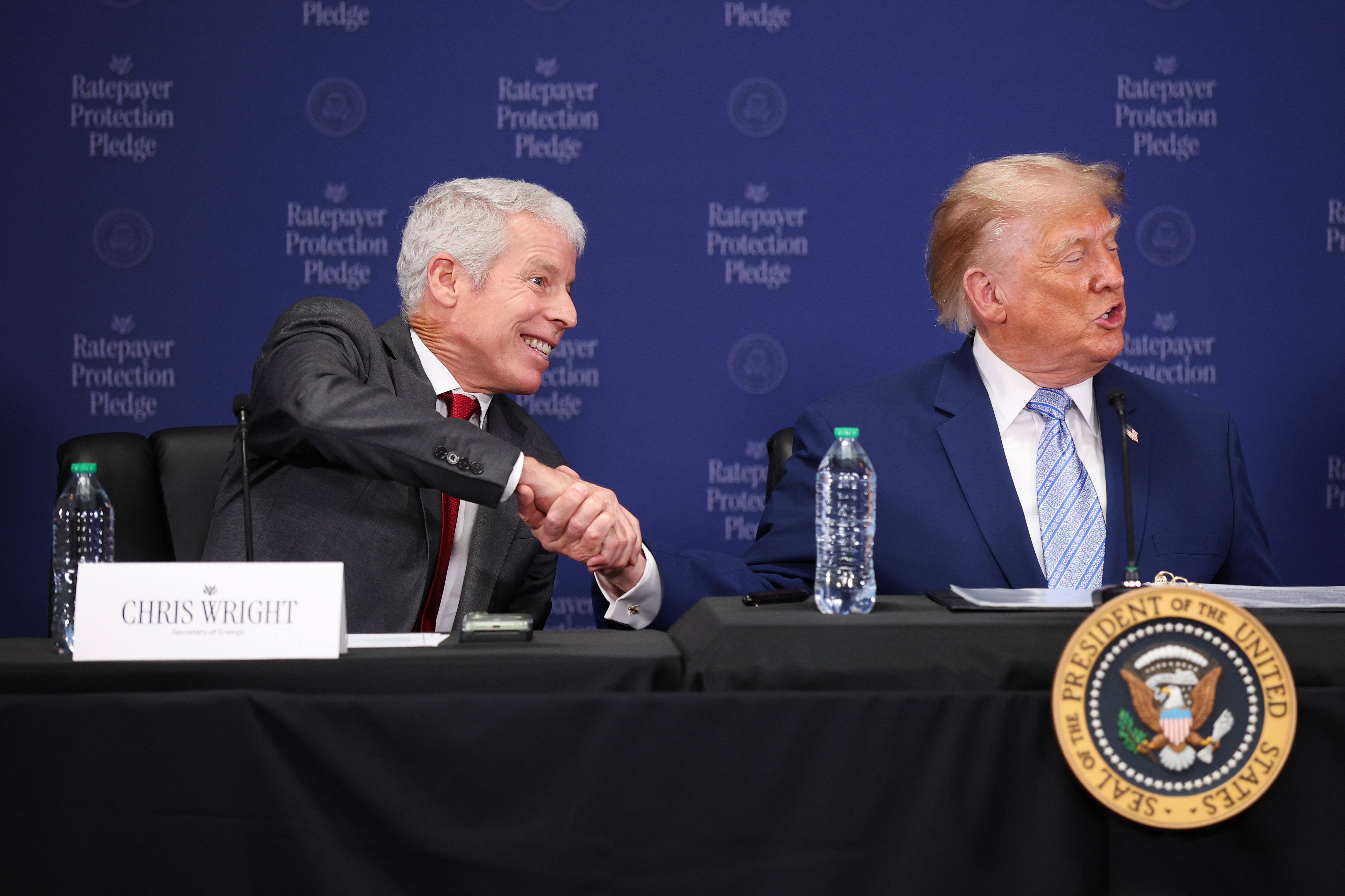 WASHINGTON, DC - JULY 23: U.S. President Donald Trump (R) shakes hands with U.S. Energy Secretary Chris Wright as he delivers remarks on the Ratepayer Protection Pledge during a roundtable at the Environmental Protection Agency headquarters on July 23, 2026 in Washington, DC.  The pledge is intended to shield taxpayers from the costs associated with electricity demands from the AI boom. (Photo by Kevin Dietsch/Getty Images)
