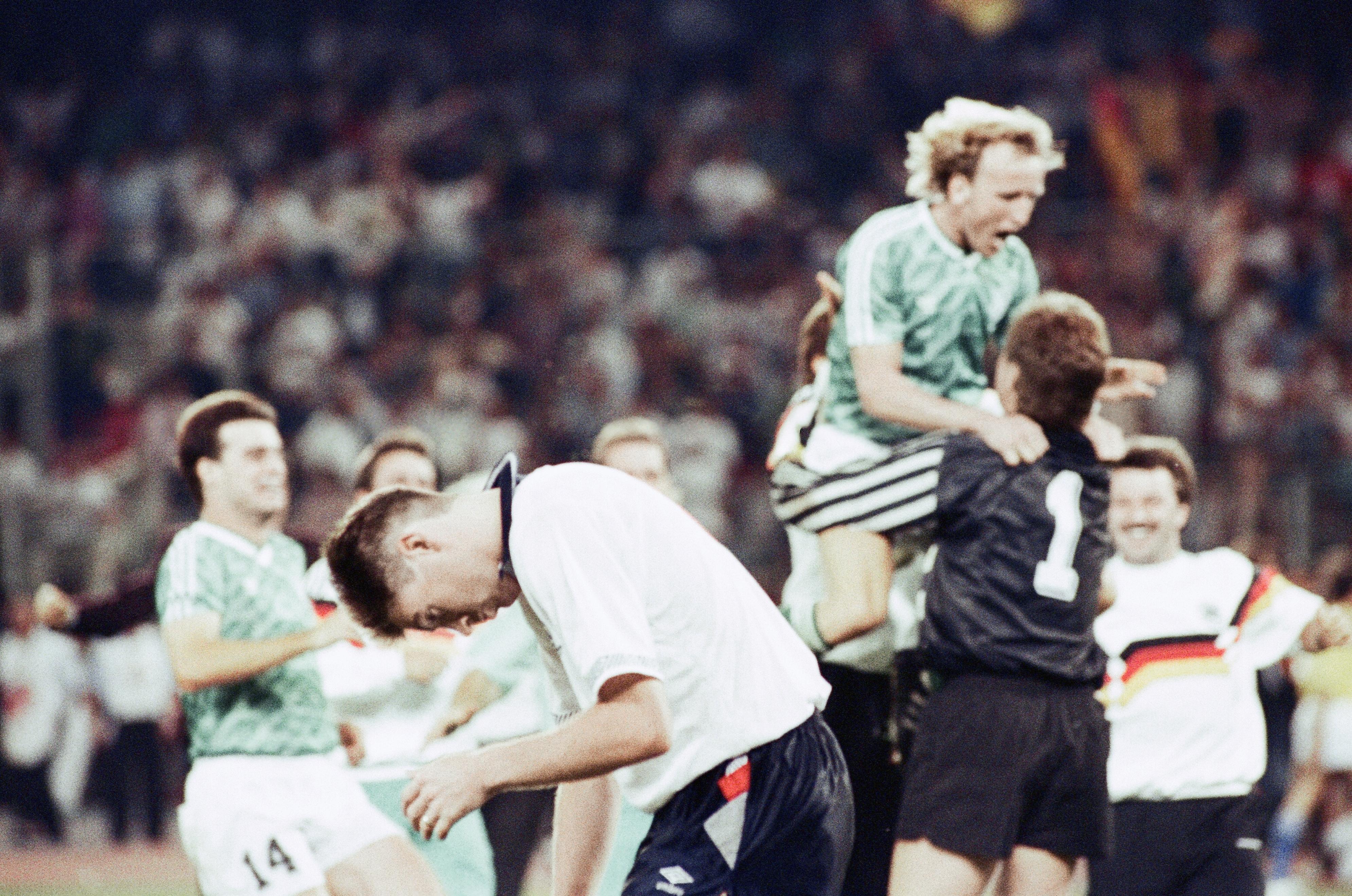 World Cup Semi Final match at the Stadio delle Alpi in Turin, Italy, West Germany 1 v England 1 after extra time, (West Germany win 4-3 on penalties), Joy for West Germany players and management staff after victory in the shootout secured their third consecutive World Cup Final appearance, In the foreground a distraught Chris Waddle hangs his head after his missed penalty sealed the West German victory, In the background Andreas Brehme congratulates hero goalkeeper Bodo Illgner, Wednesday 4th July 1990. (Photo by Arnold Slater/Daily Mirror/Mirrorpix via Getty Images)