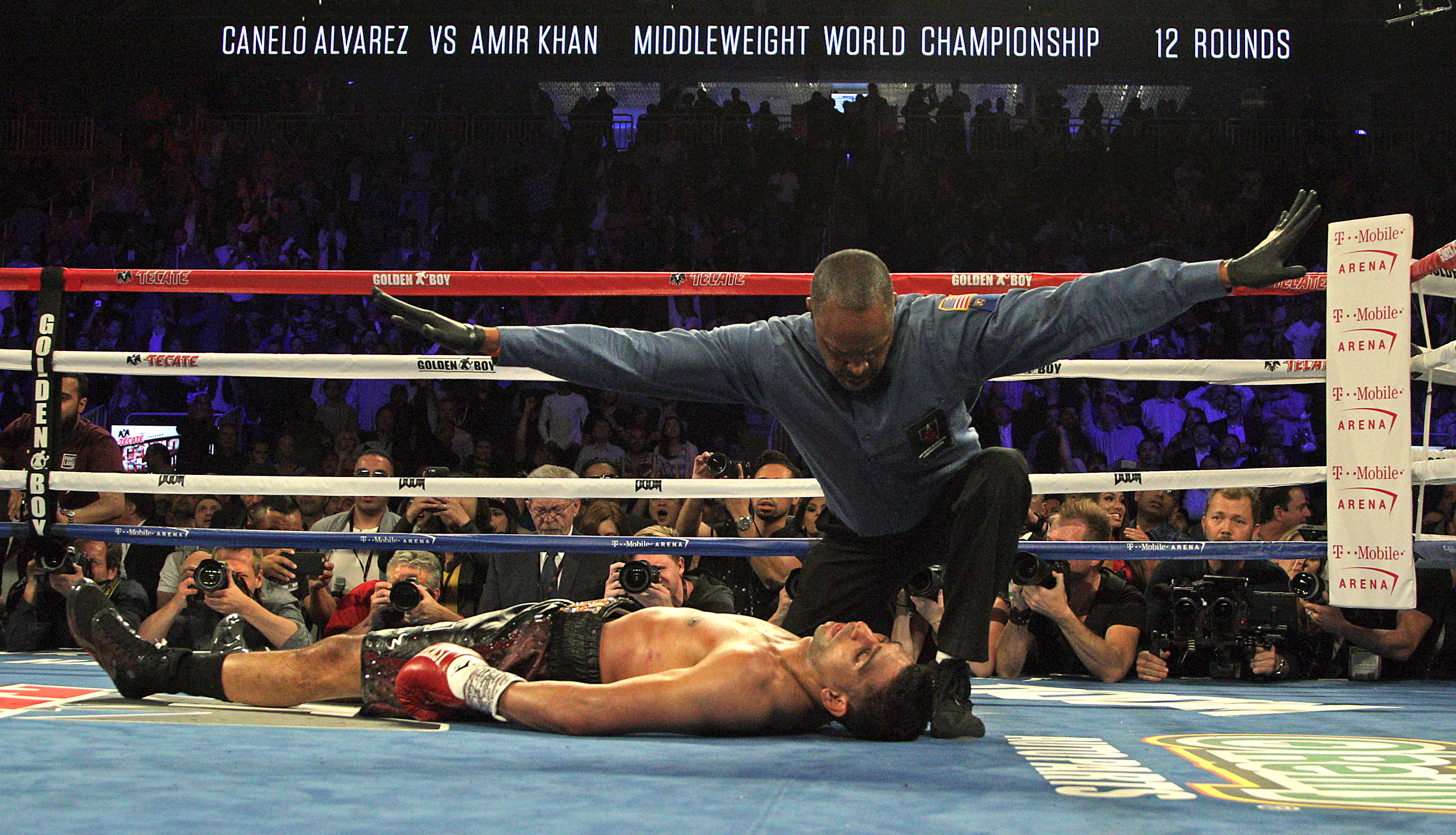 Referee Kenny Bayless counts out Amir Khan of Great Britain in the sixth round after  being decked by Saul Canelo Alvarez of Mexico (out of frame) in their WBC middleweight title fight at T-Mobile Arena on May 7, 2016 in Las Vegas, Nevada. (Photo by John Gurzinski / AFP via Getty Images)