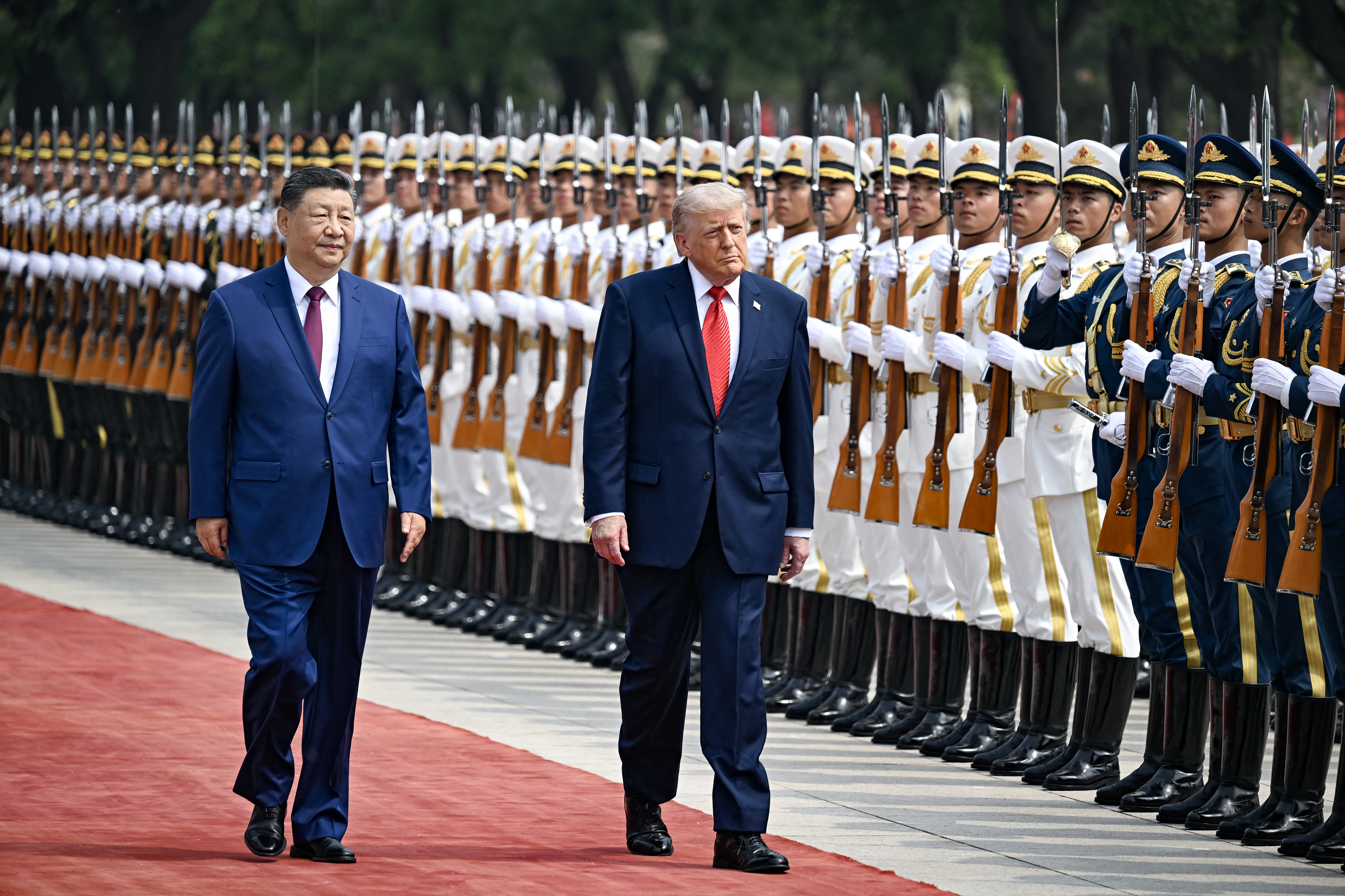 US President Donald Trump (R) and China's President Xi Jinping inspect a guard of honour during a welcome ceremony at the Great Hall of the People in Beijing on May 14, 2026. (Photo by Kenny HOLSTON / POOL / AFP via Getty Images)