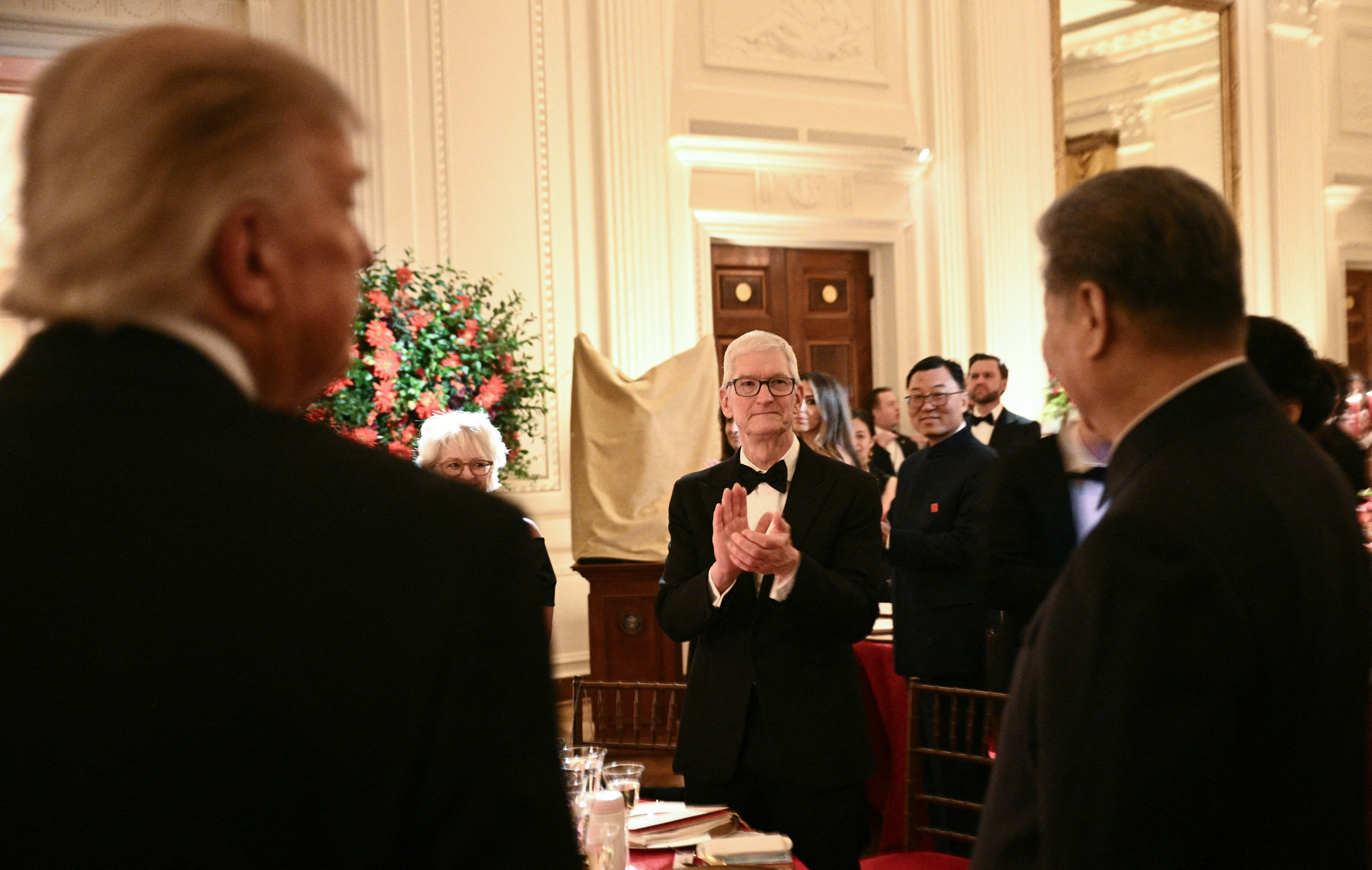TOPSHOT - Apple Chairman Tim Cook (C) applauds as US President Donald Trump (L) and Chinese President Xi Jinping (R) arrive for a state dinner at the White House in Washington, DC, on September 24, 2026. President Xi is on a State visit to the United States from September 23 to 25. (Photo by Brendan SMIALOWSKI / AFP via Getty Images)