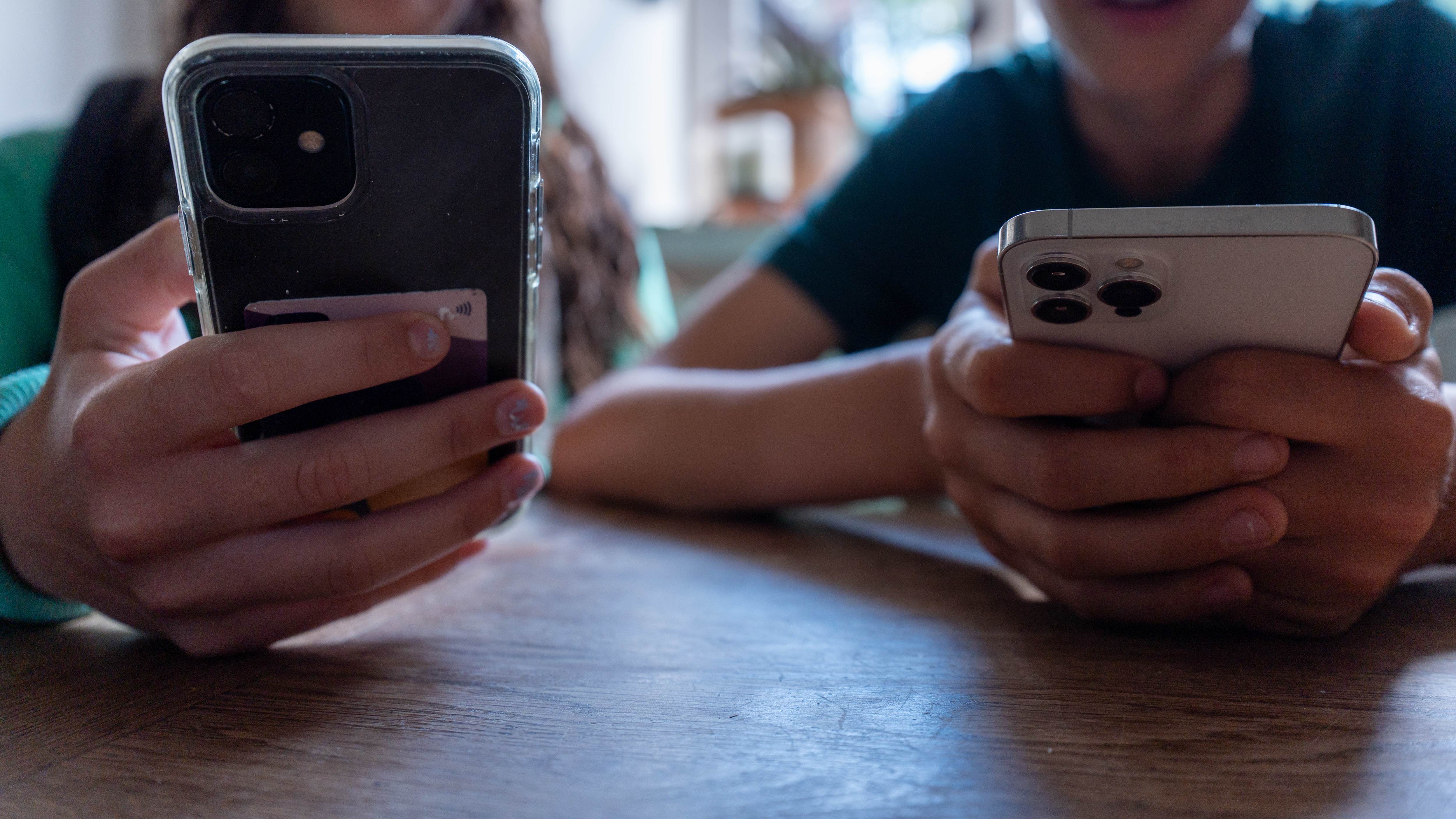 A person looking at a smartphone with a high bill notification