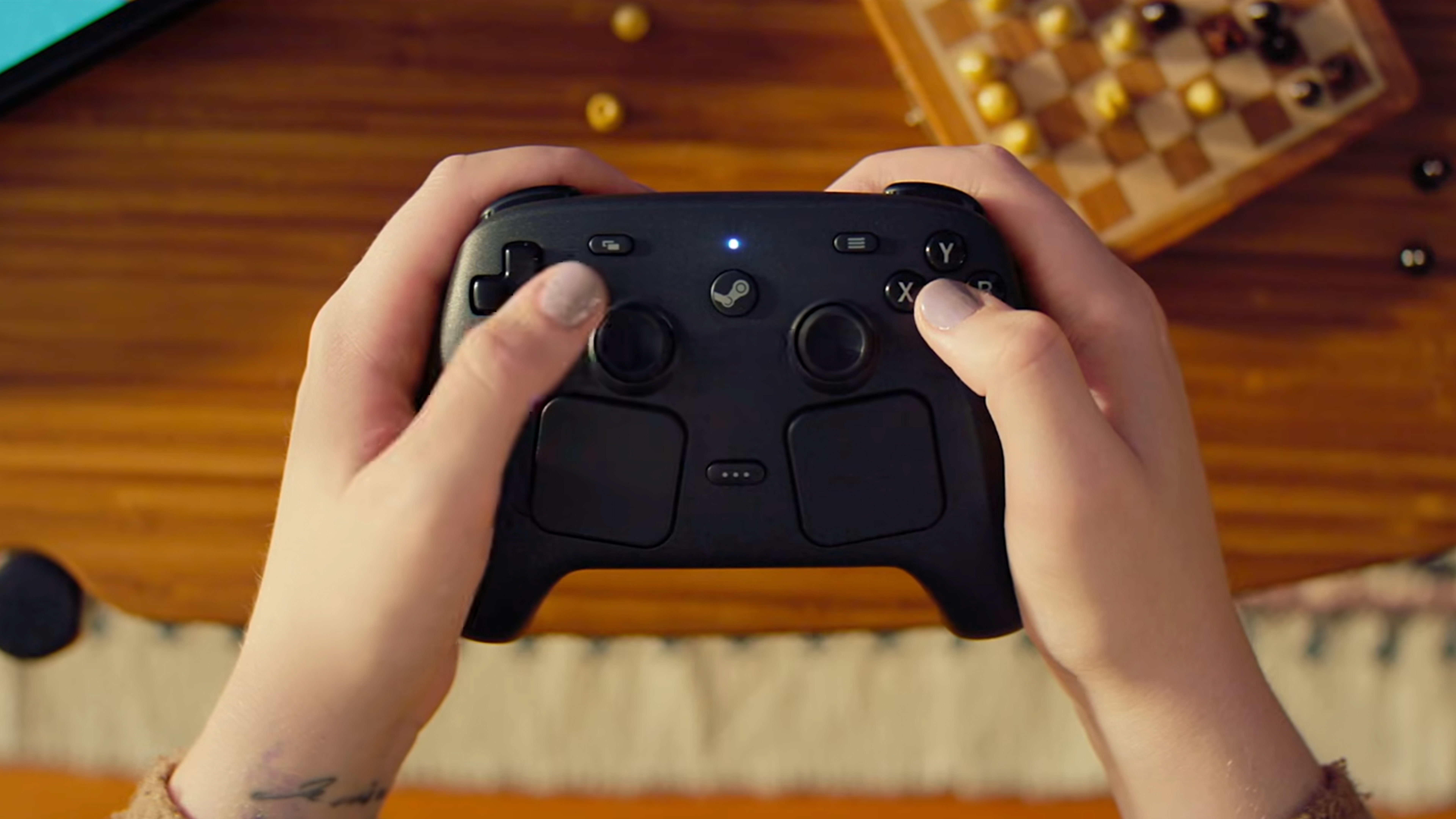 Someone holding the new Steam Controller, with trackpads visible.