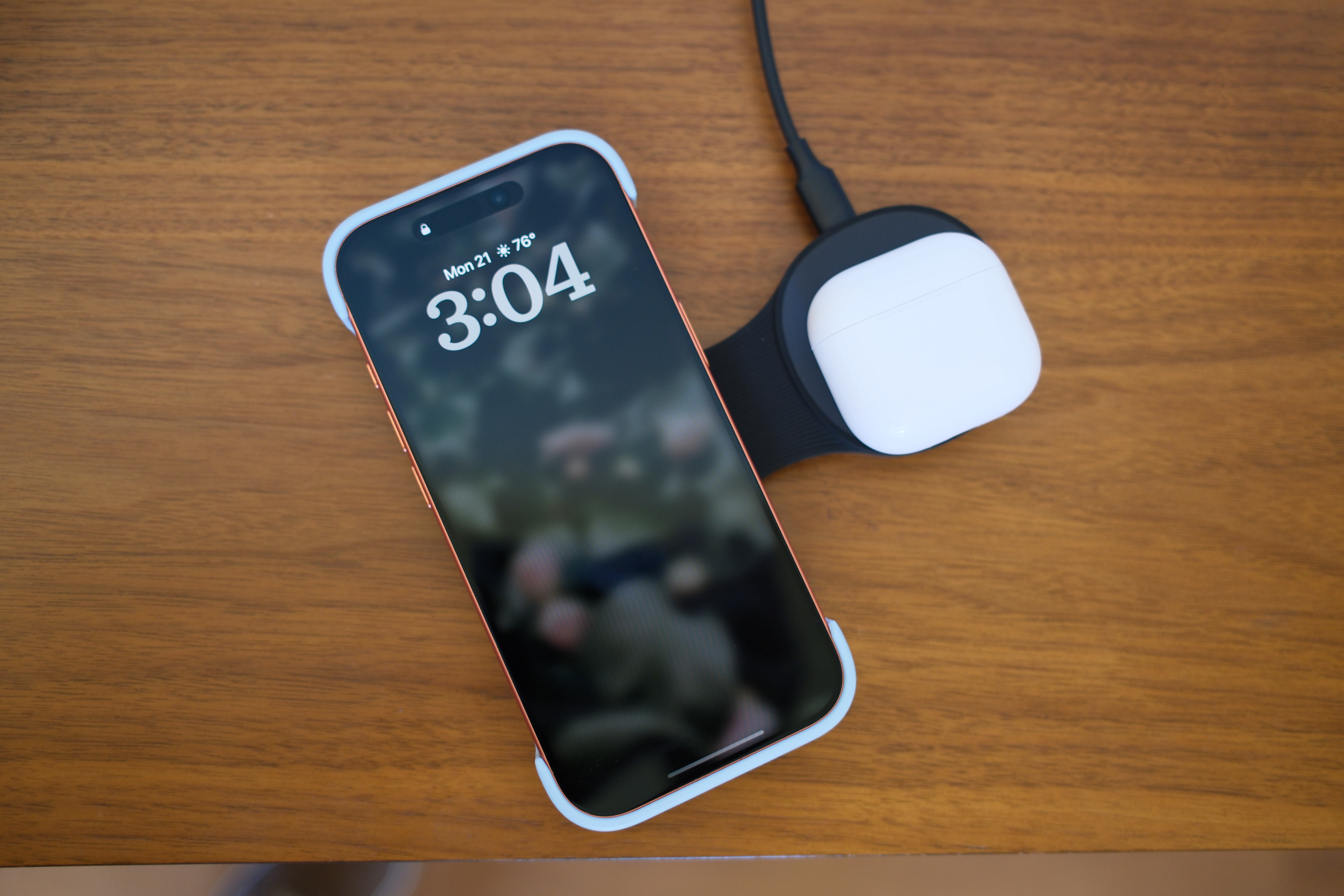 a phone and airpods sitting on the ugreen 25W foldable charger