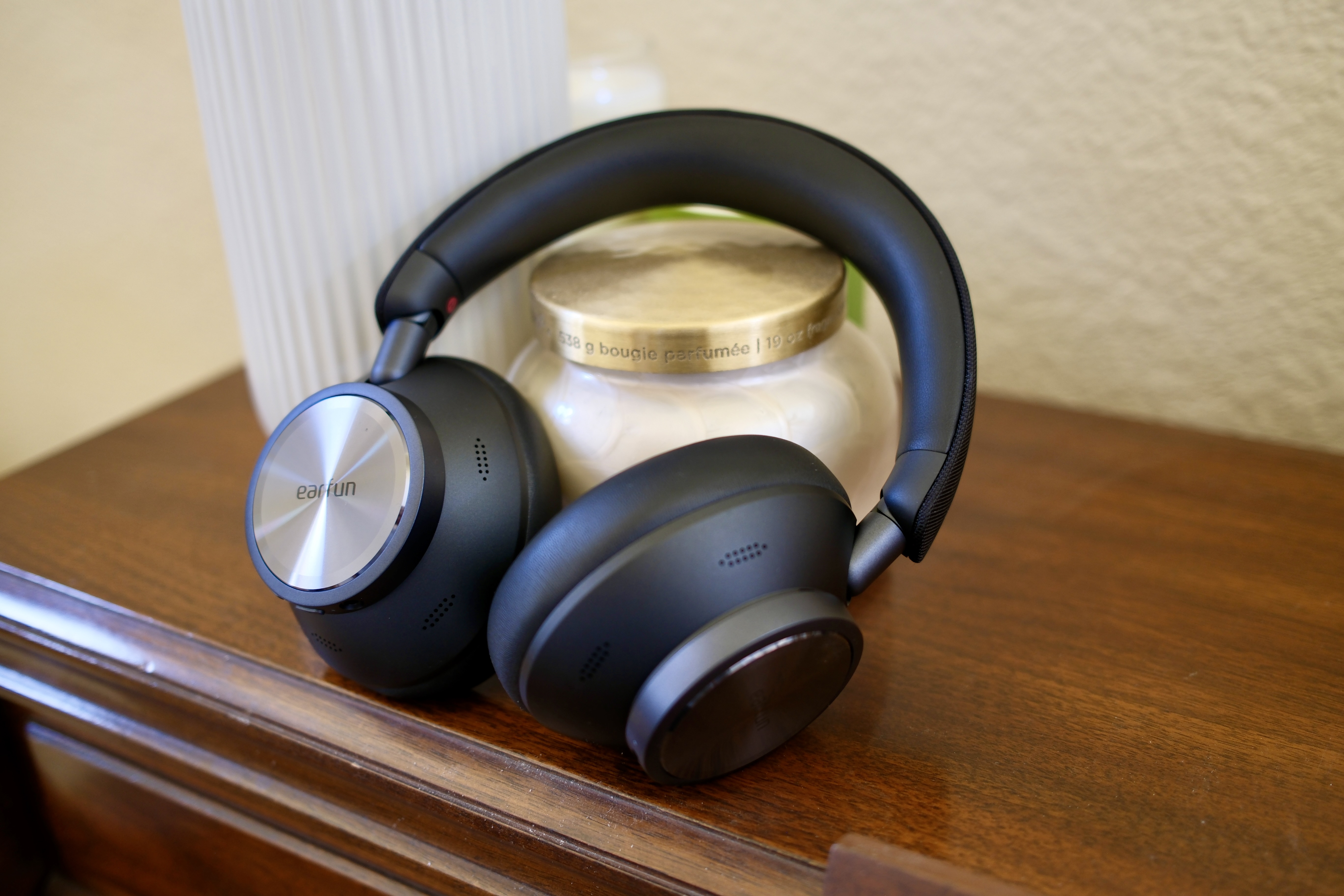 EarFun Wave Pro X leaning against a candle