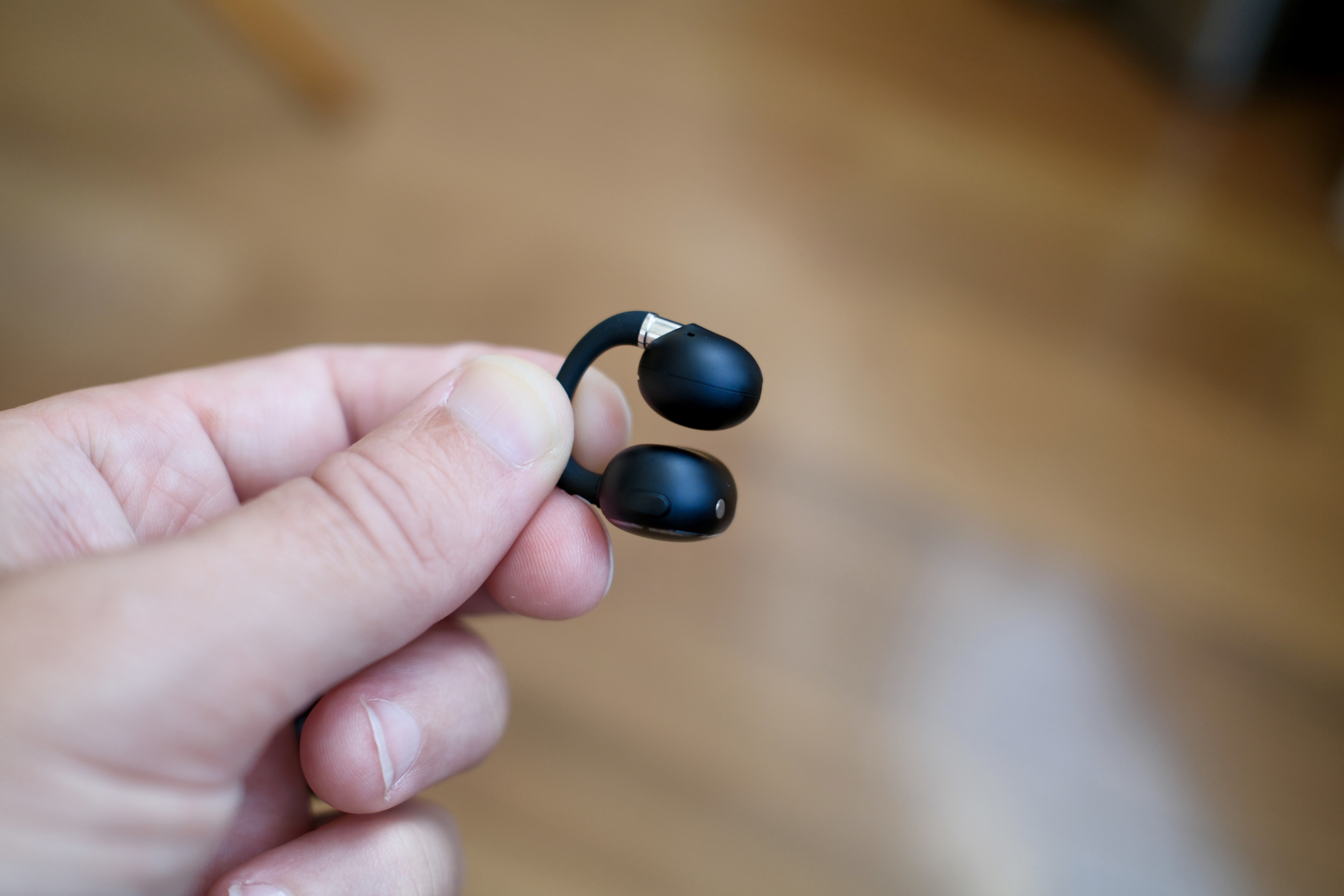 hand holding a single EarFun Clip 2 bud