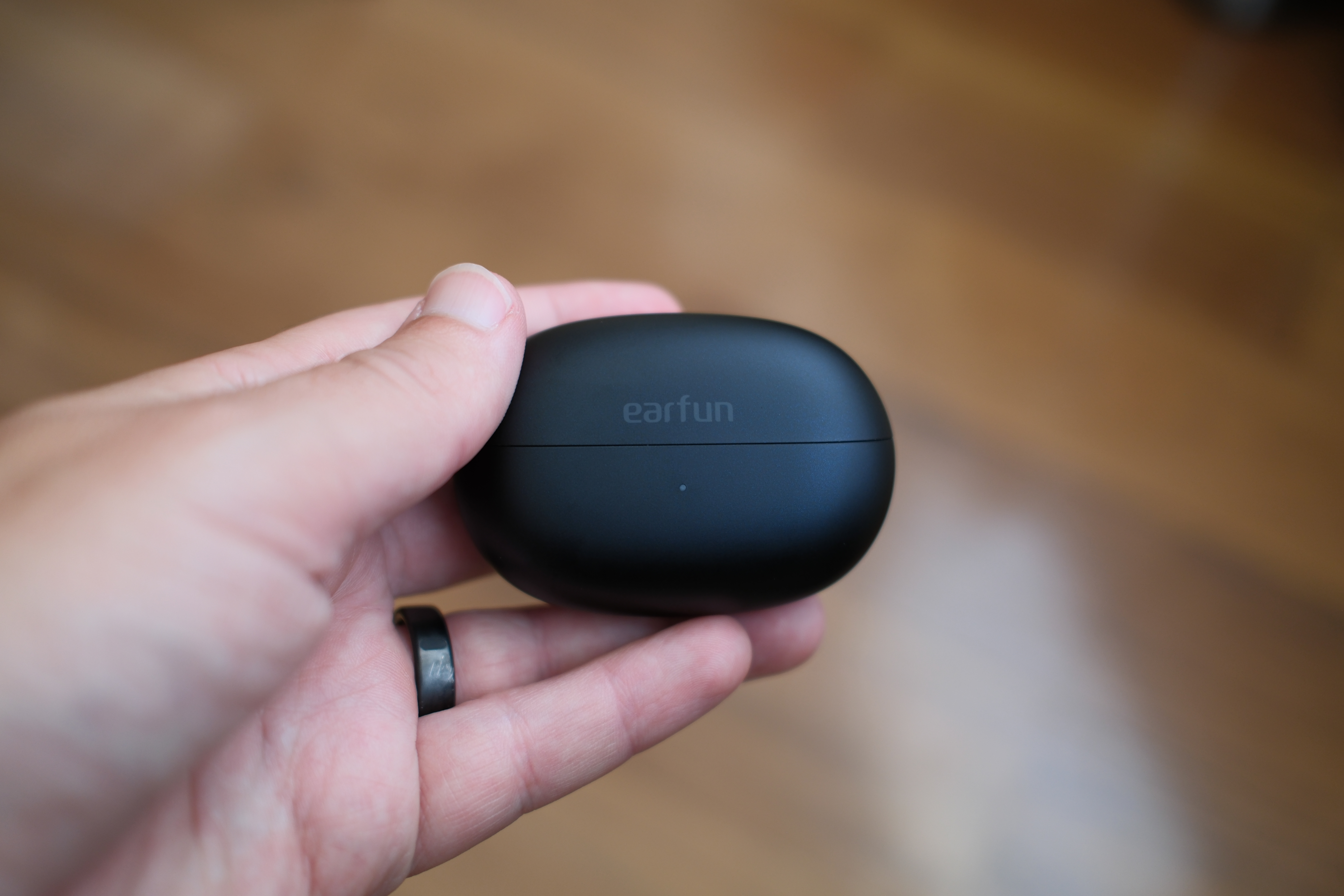 hand holding EarFun Clip 2 case closed