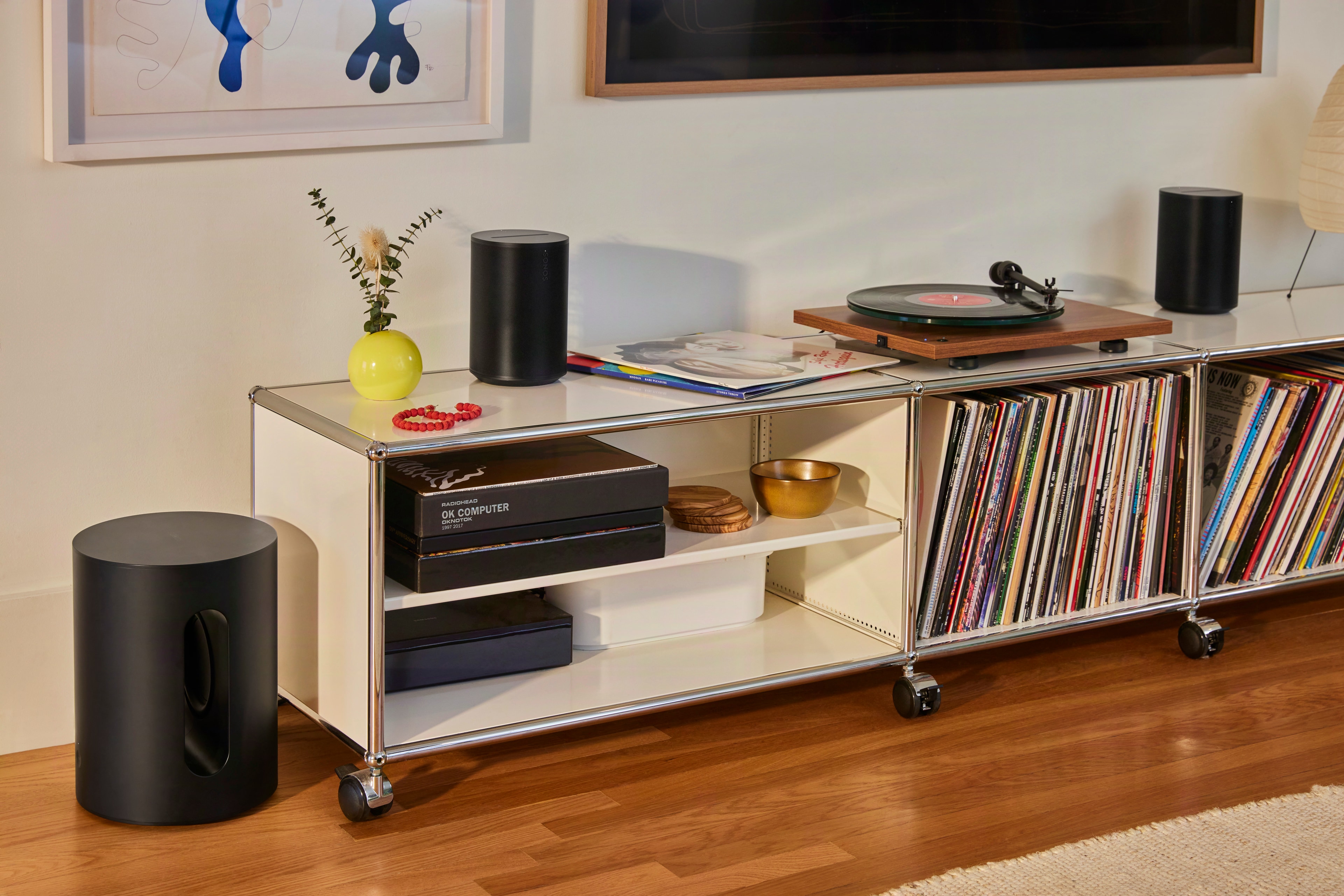 A pair of Sonos Era 100 SL speakers with a turntable.